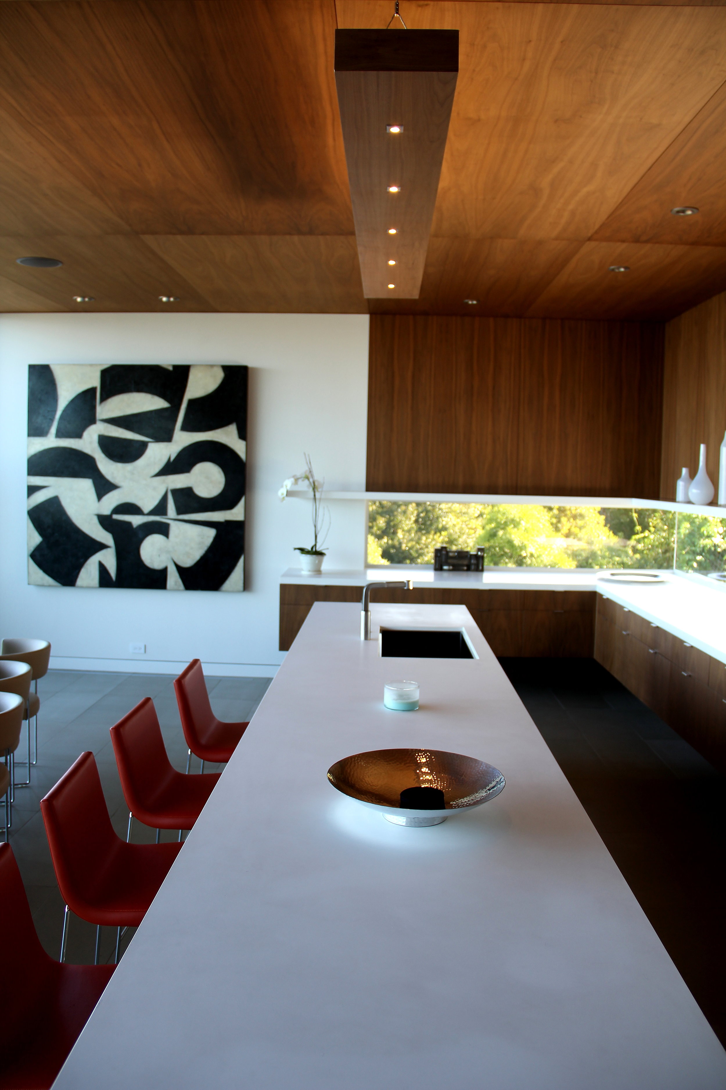  Contemporary kitchen with a custom walnut lightbox over the island. 