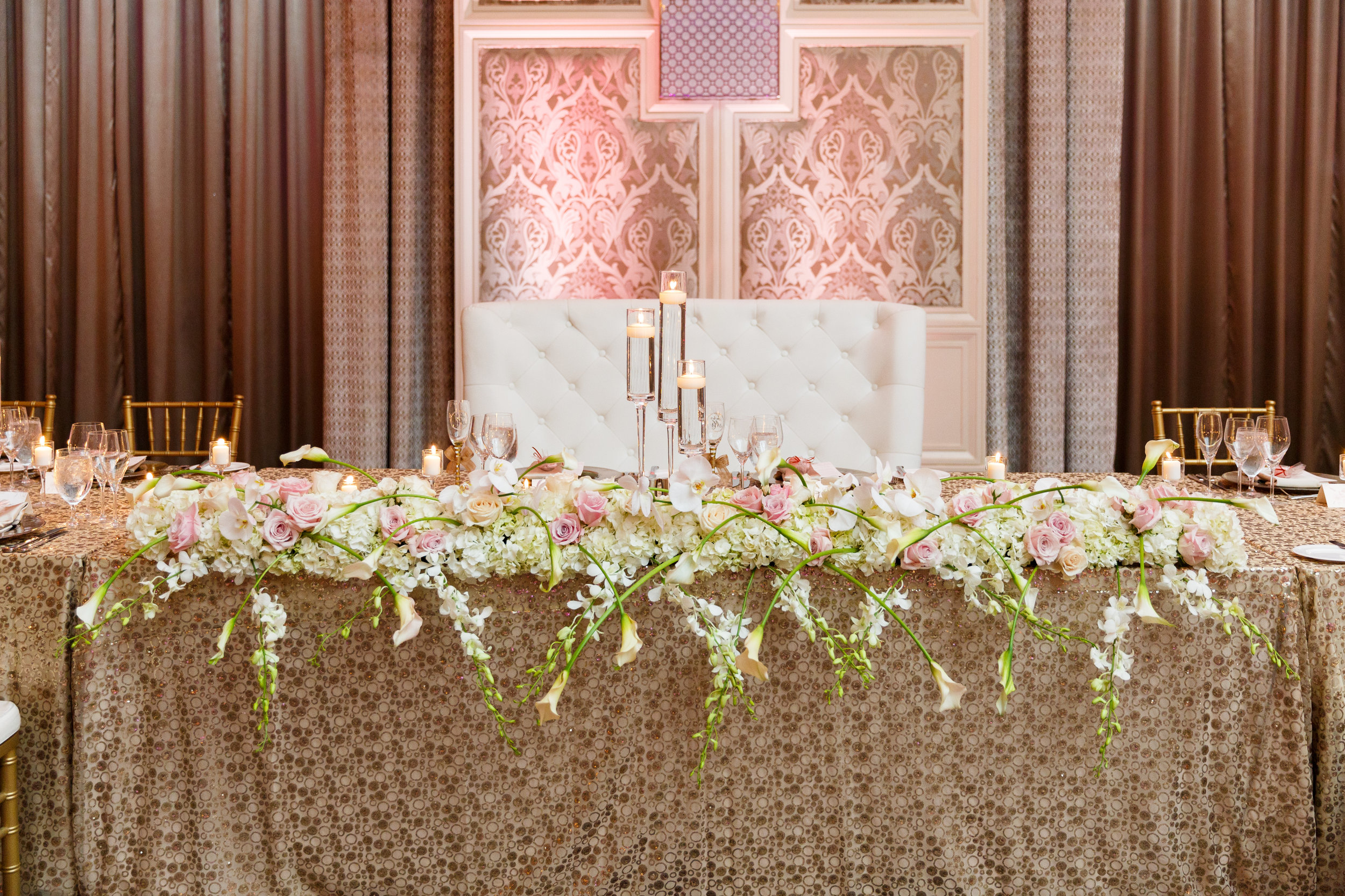 Overflowing flower runner on head table with sequin linen at Four Seasons Orlando