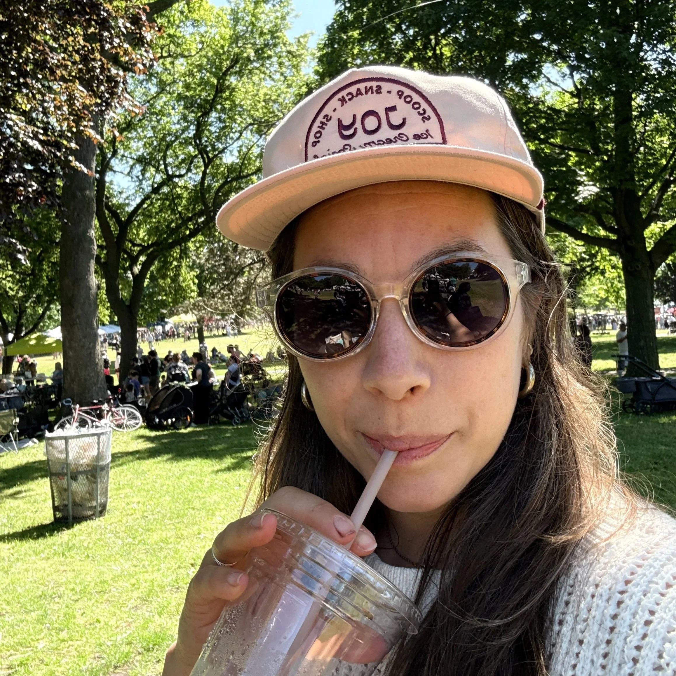 woman drinking iced coffee at farmers market