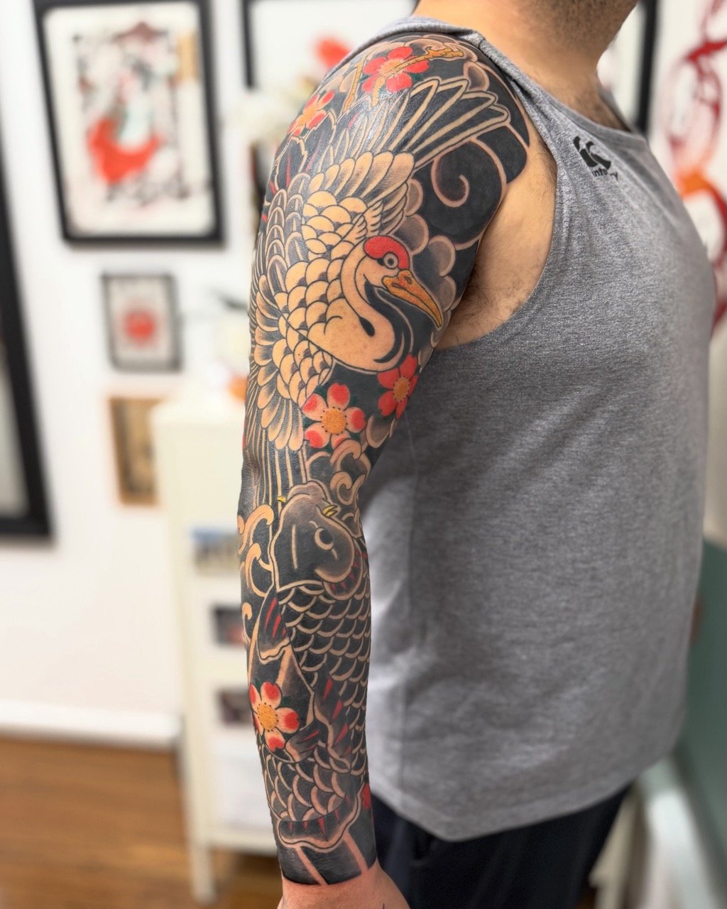 Traditional Japanese koi and crane sleeve tattoo with muted colours and sakura