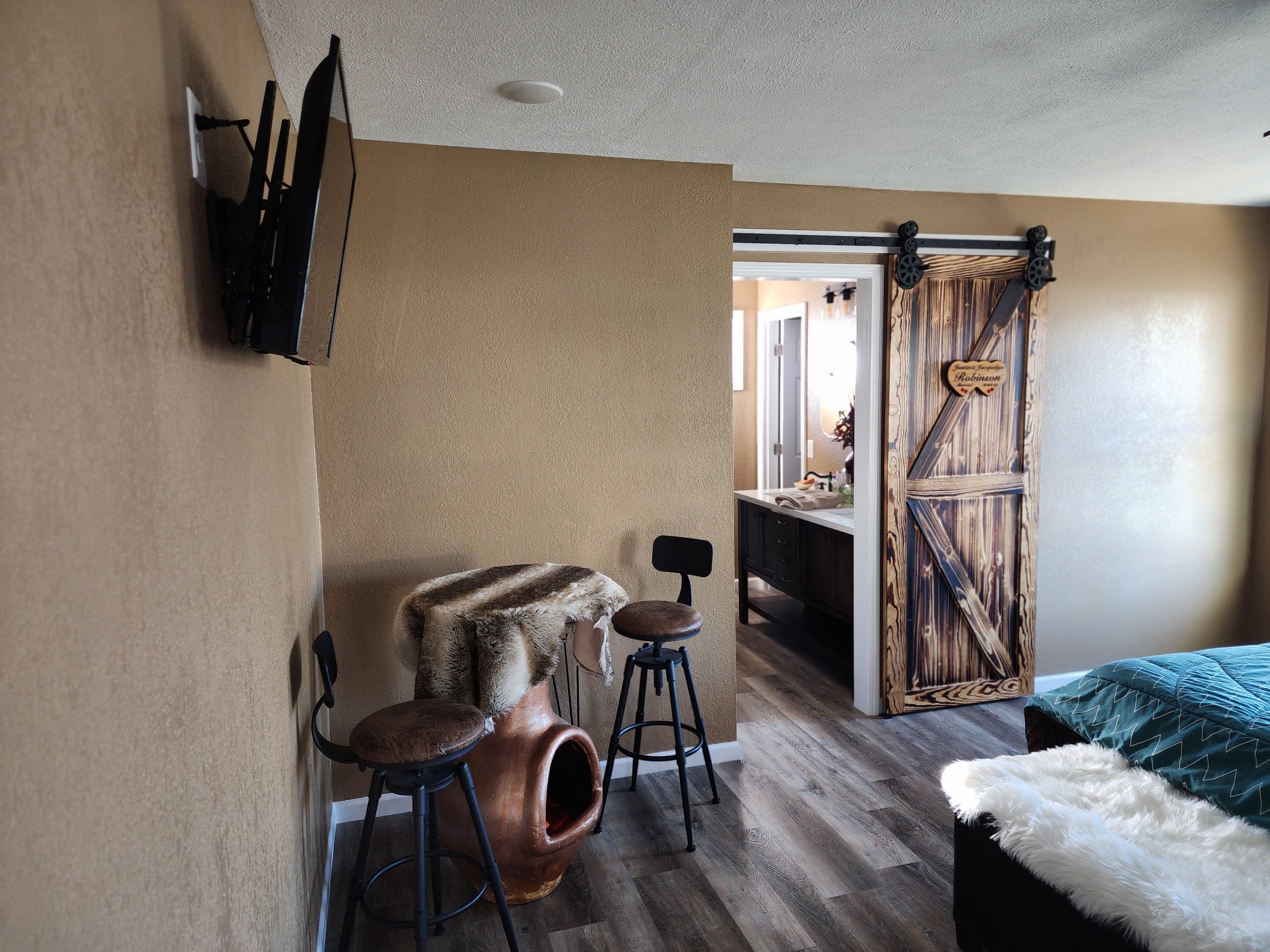  Remodeled bedroom featuring dark wood floors and barnwood doors leading into renovated bathroom 