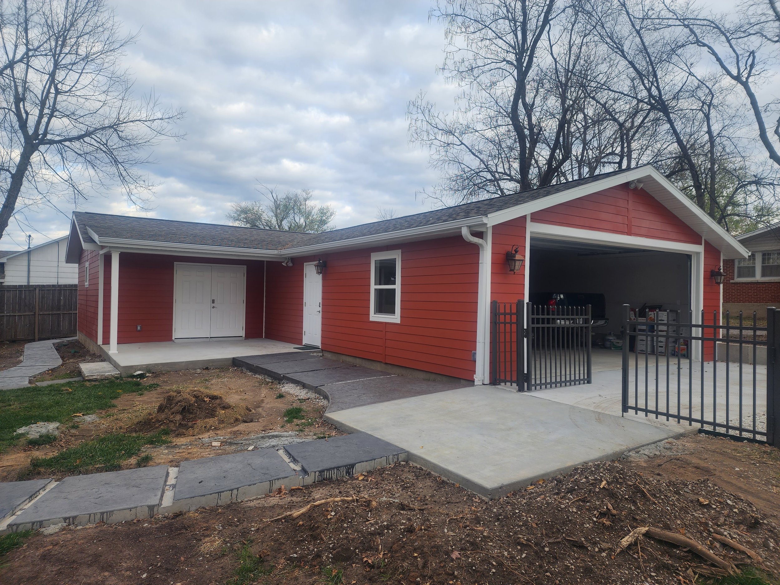  newly built garage and outbuilding with red siding and white doors 