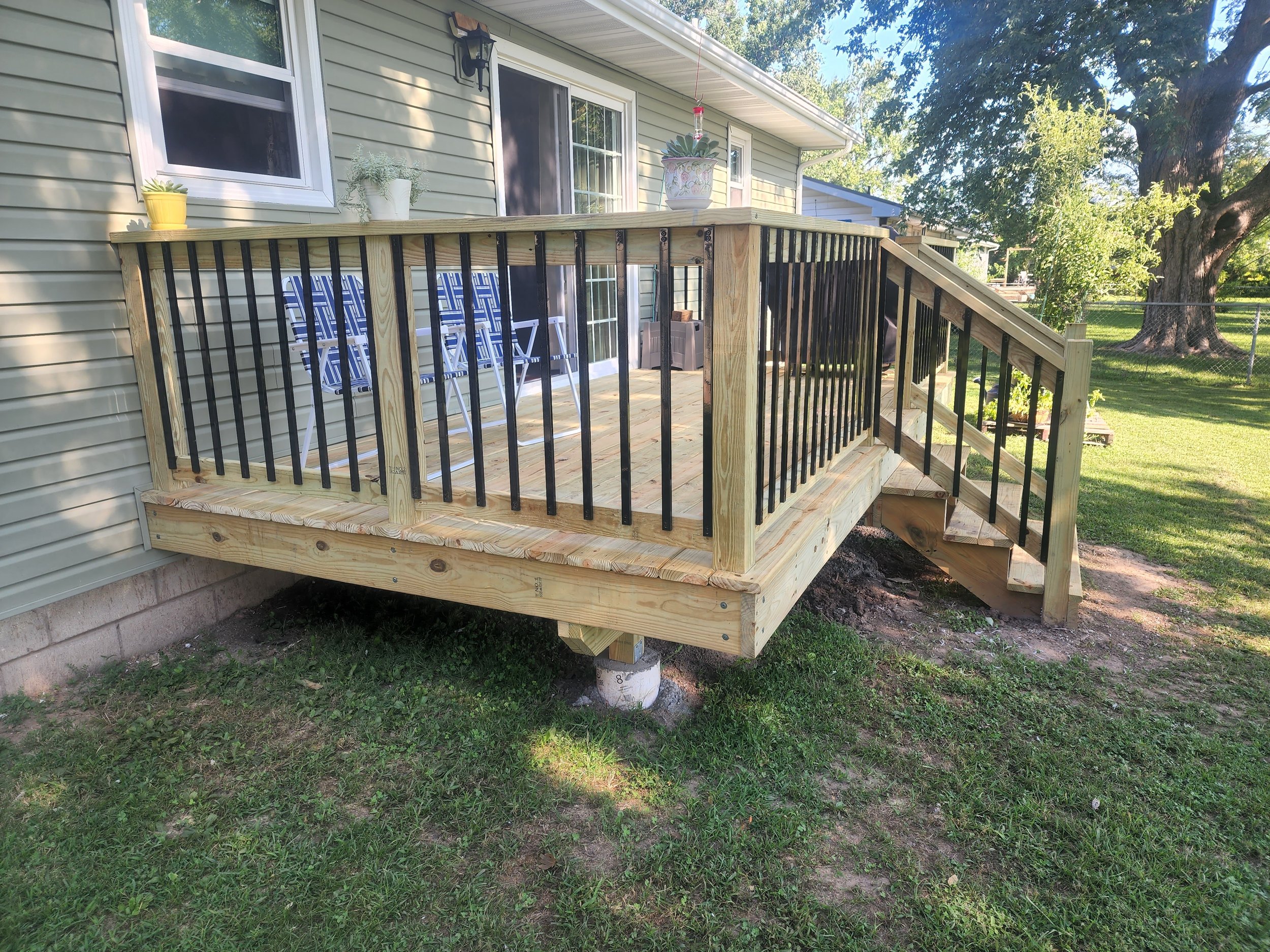  view from side of freshly constructed deck with iron railings 