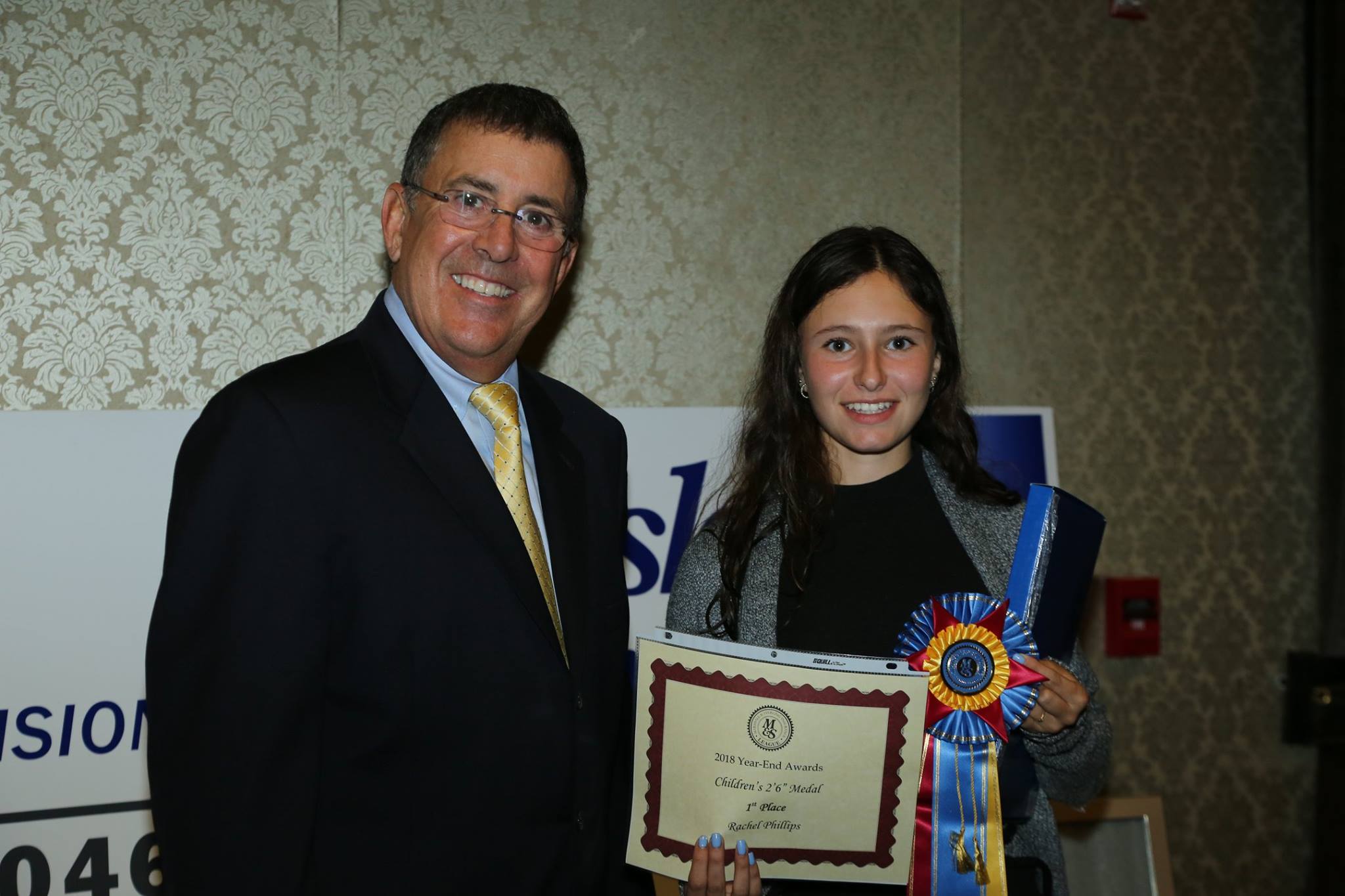 Don Graves presenting award and ribbon to young woman.