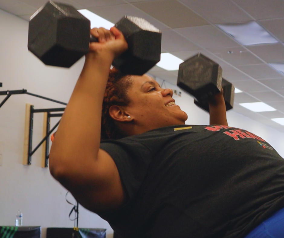 Woman performing a dumbbell chest press during a personal training workout