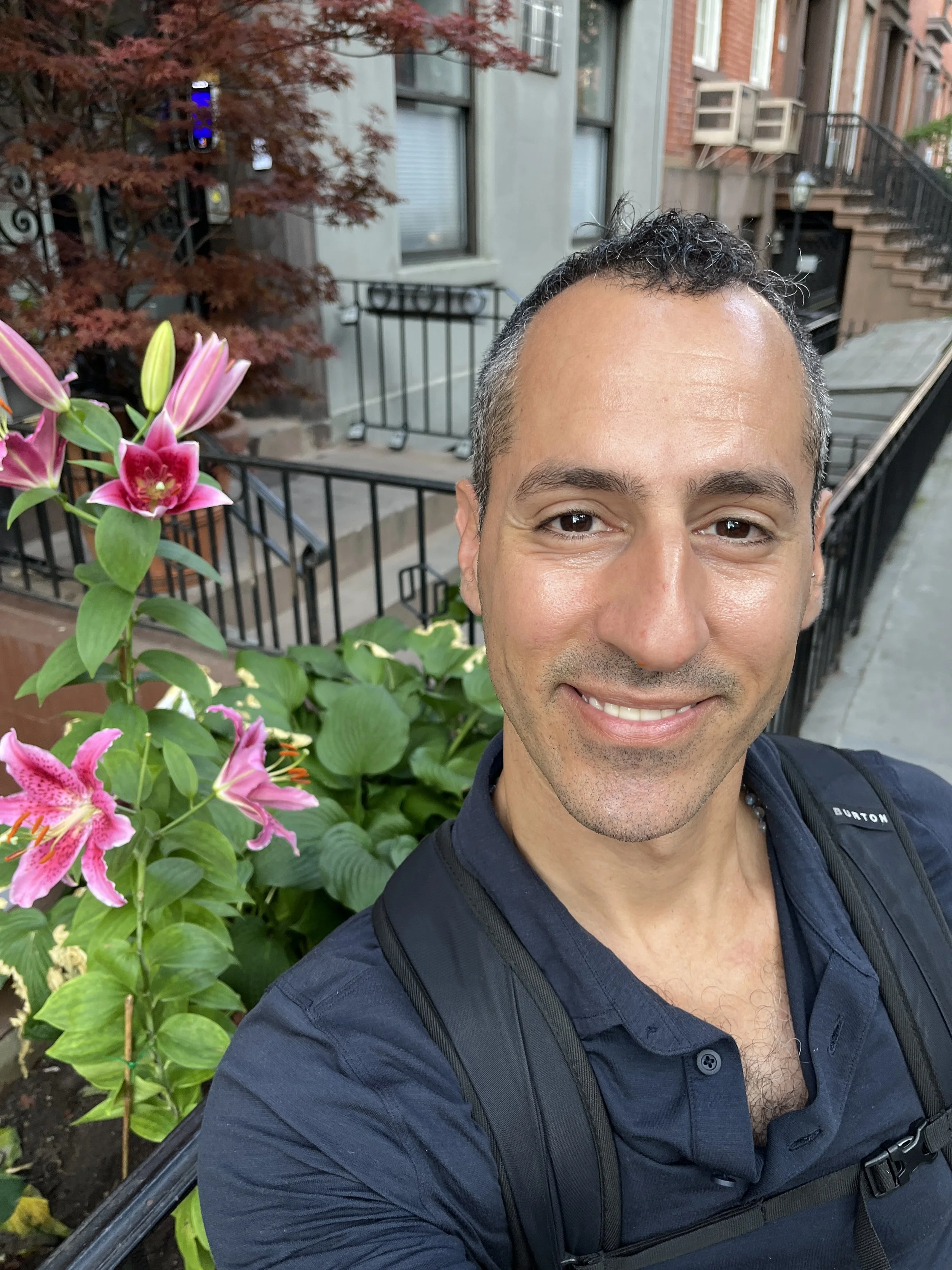 Jonathan Angelilli Smiling with flower in Chelsea NYC - Private Strength & Nervous System Coaching for Women 40+ going through Menopause
