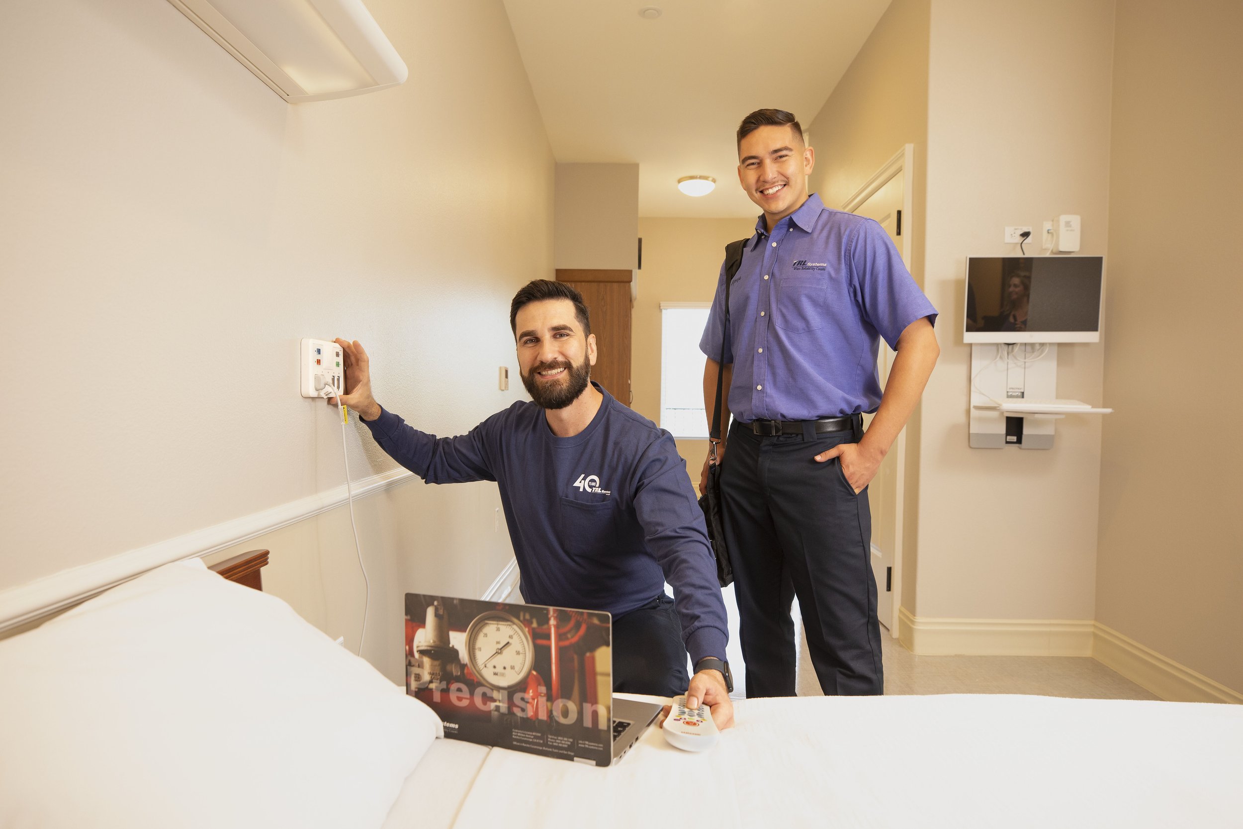 Two TRL Systems employees adding checking alarm system in hospital