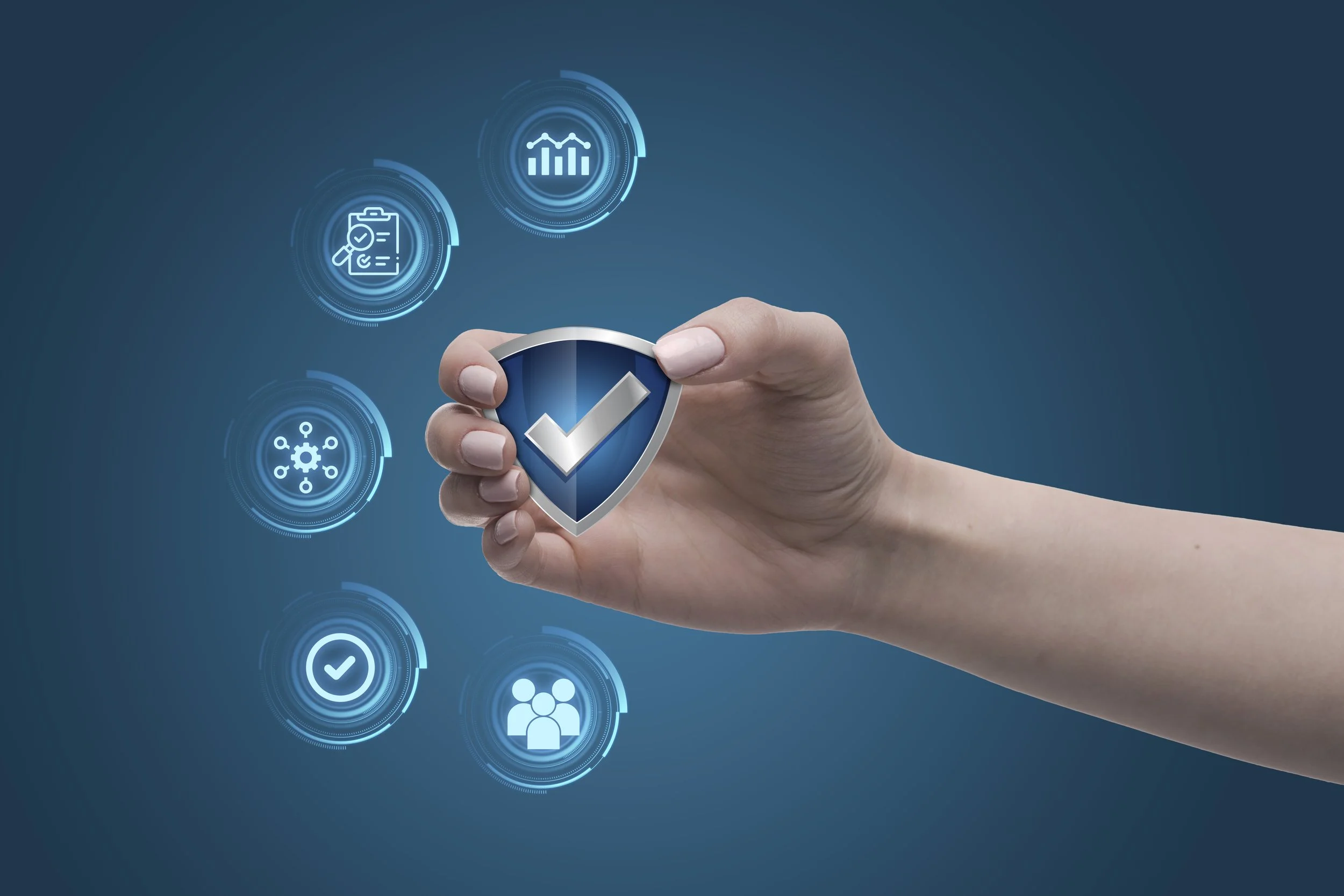 A hand holding a shield with a checkmark against a digital graphic background showing security and data icons.