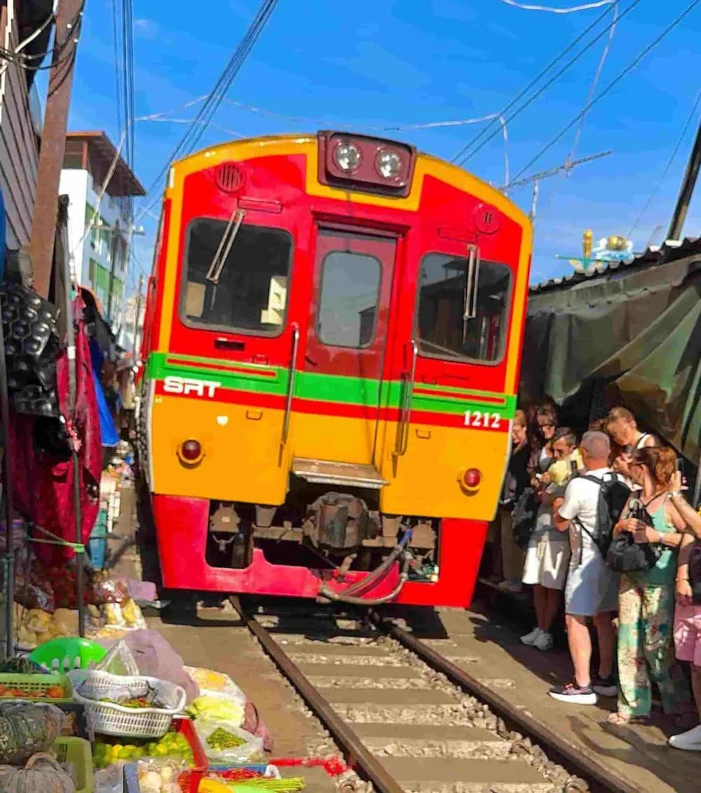 Train passing through the Railway Market at 'Mae Klong' in Thailand, showcasing the unique market scene as vendors swiftly retract their stalls with private tour guide from Bangkok