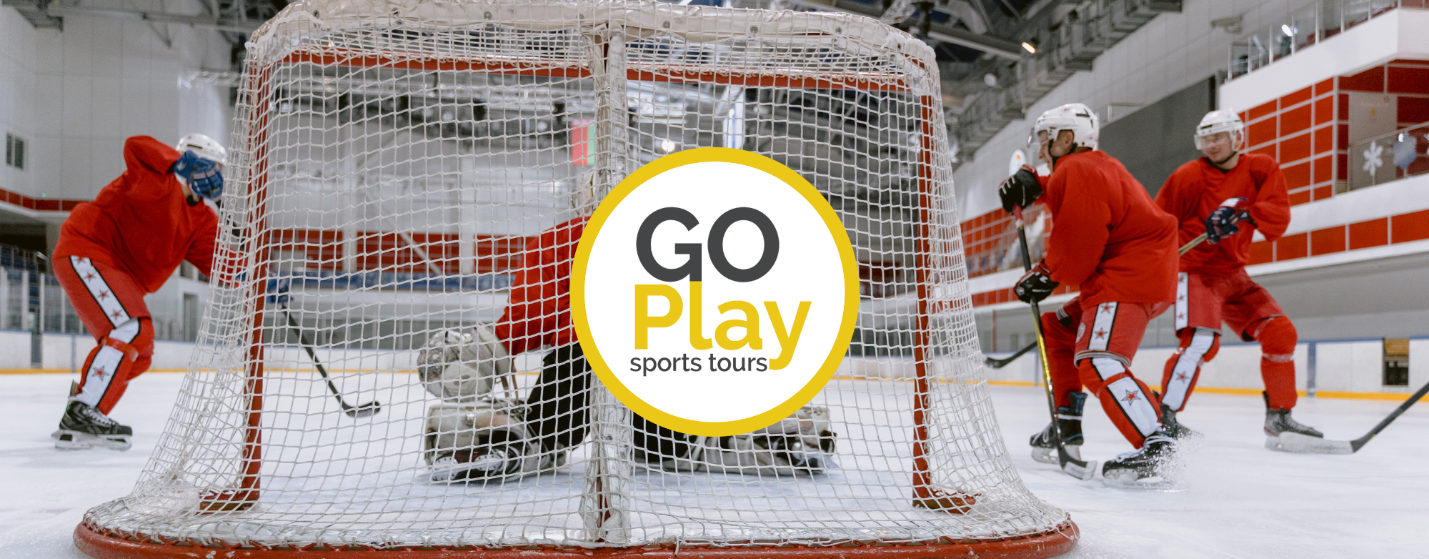 Hockey players on an ice rink during a game or practice session, with a focus on the goal area and a central circular logo that reads 'Go Play sports tours'