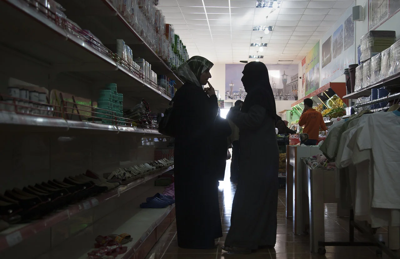 Women talk at grocery store in the Syrian camp