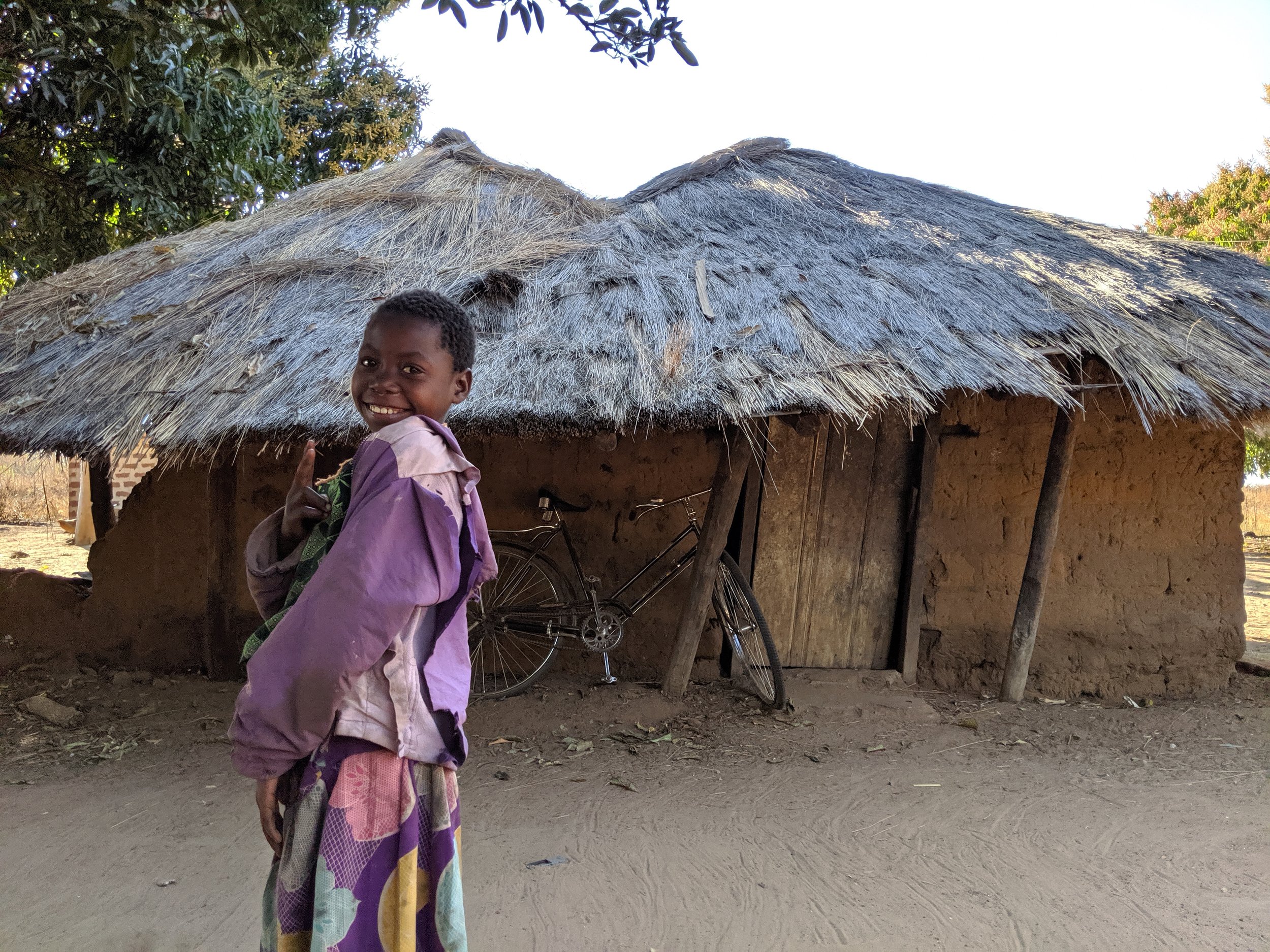 Another of Charles's family's houses. The girl pictured is one of the daughters of the piggery caretakers. She's always smiling and singing to herself. She and her sisters have very pretty singing voices.