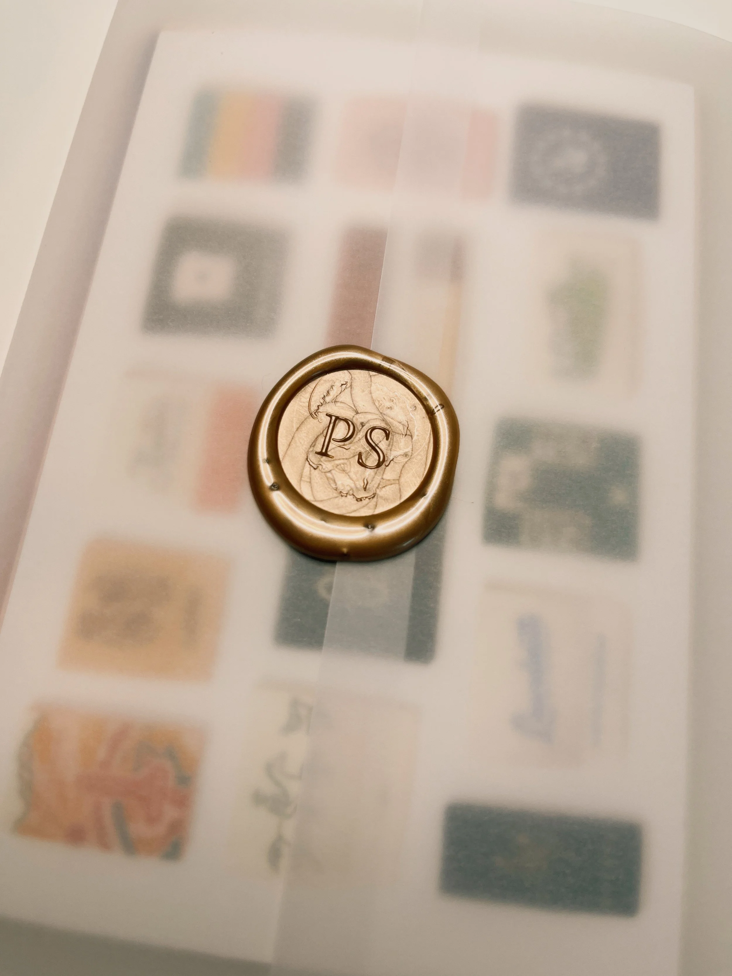 Postcards in an envelope with a wax seal of PS for Edition 01 of The Postcard Société, postcard correspondence subscription box curated by social and cultural psychologist and travel psychologist Dr. Katie Blake, PhD.