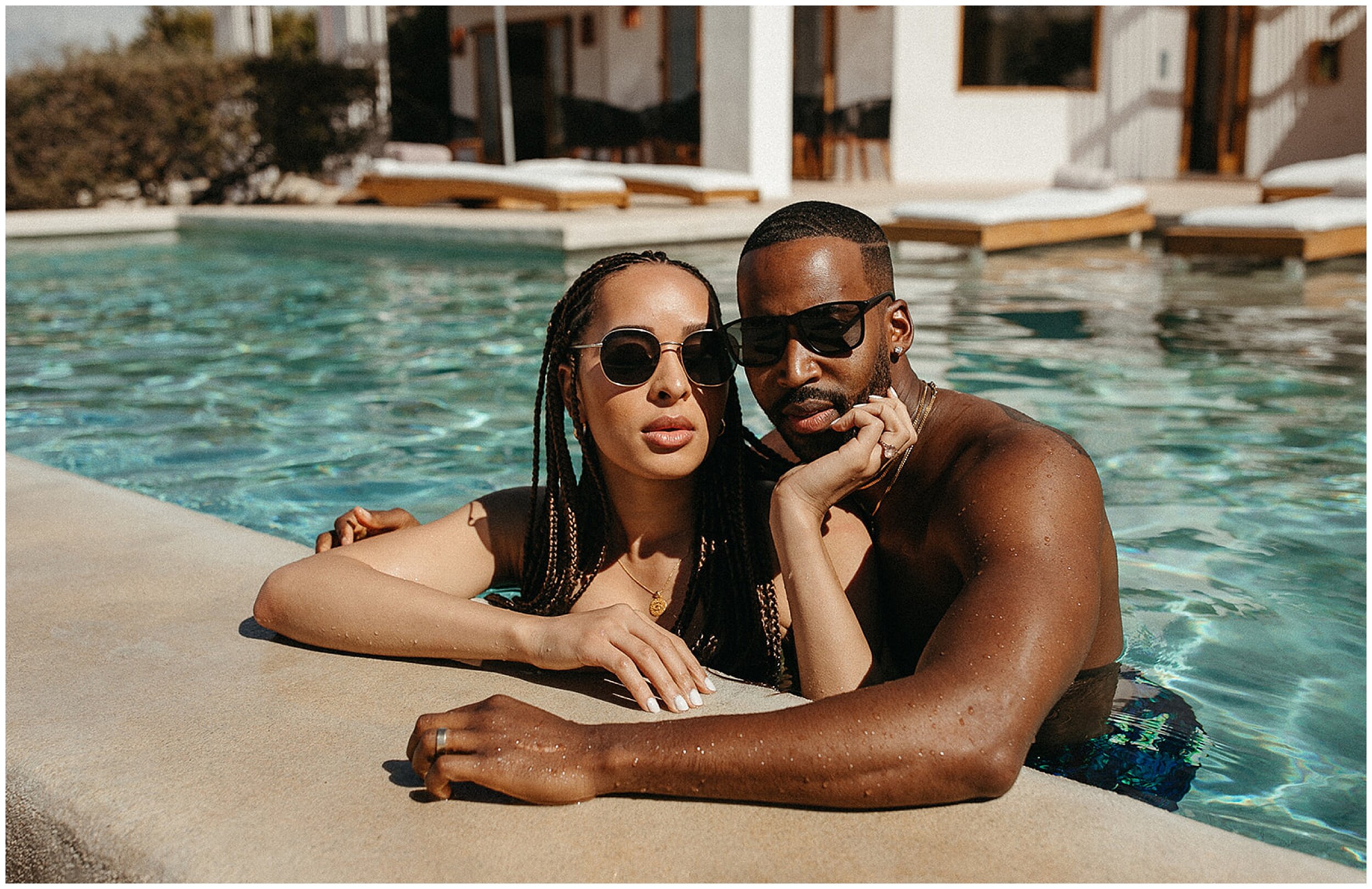 couple wearing sunglasses in pool