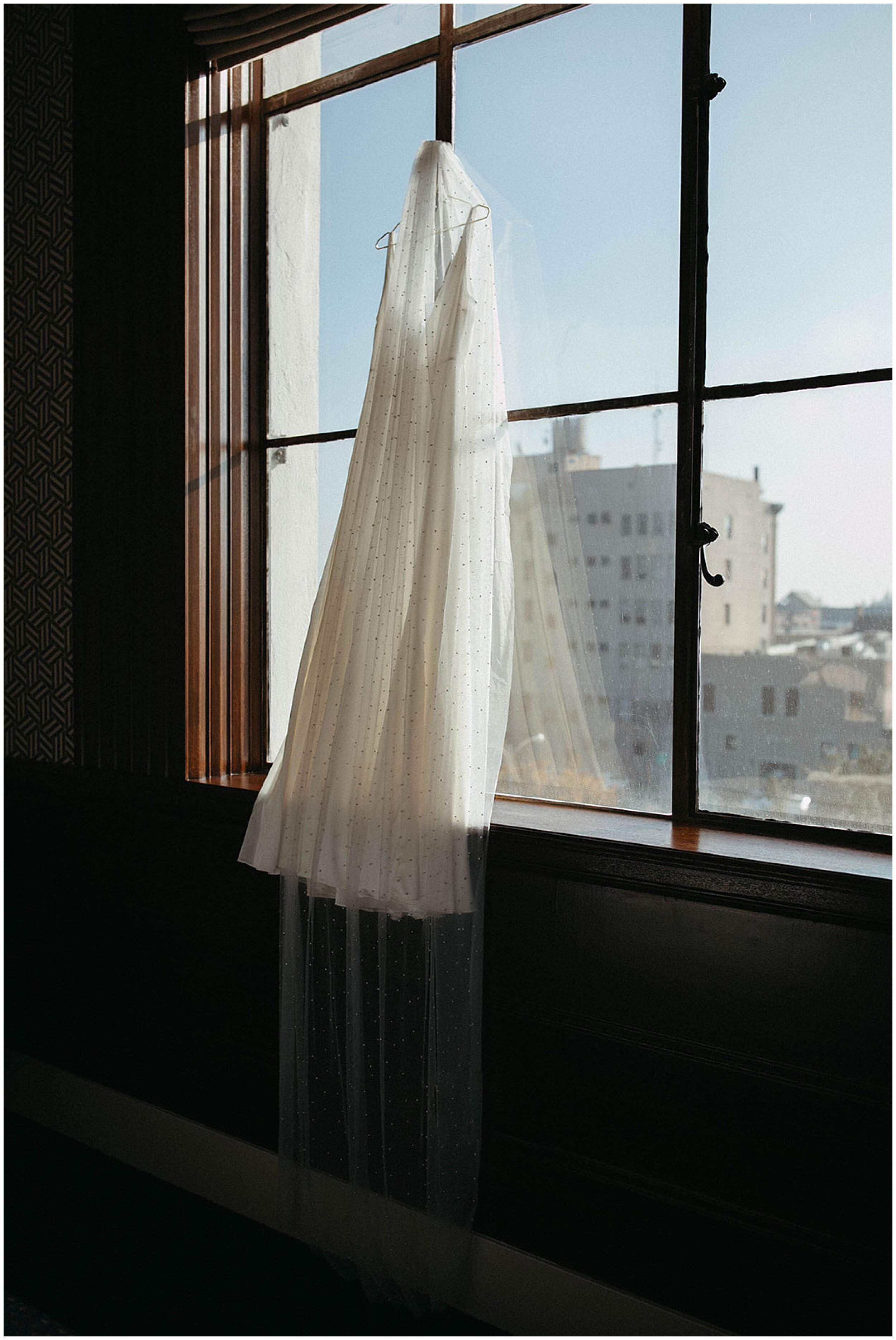 wedding dress hanging on window