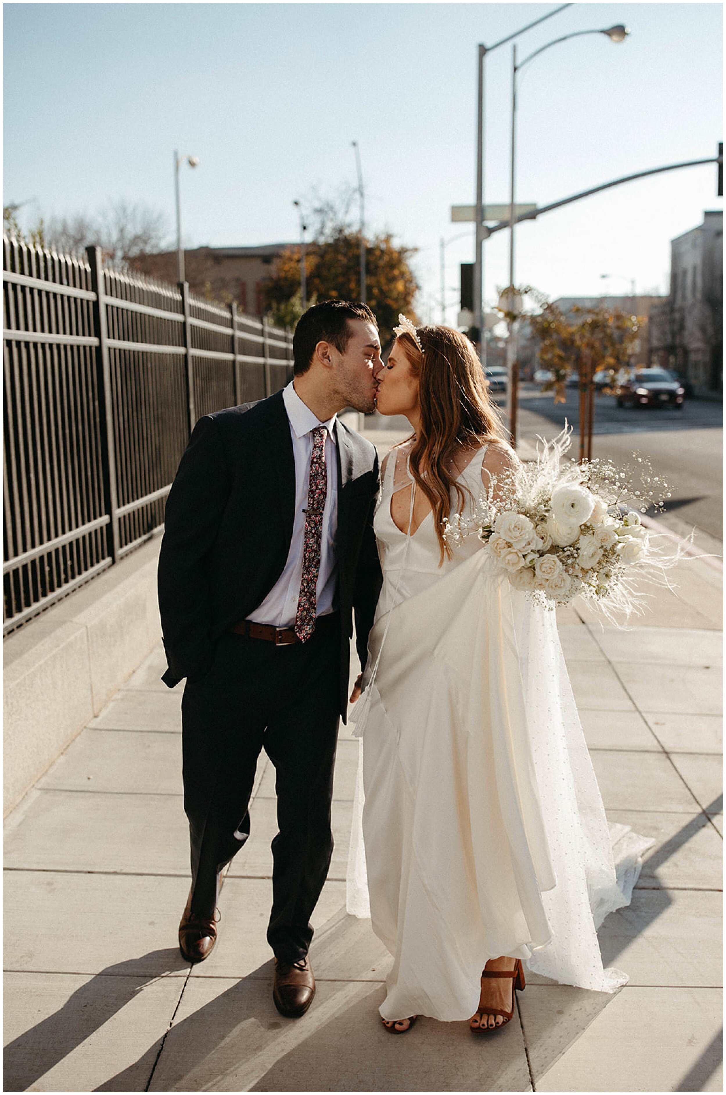 bride and groom kissing on street