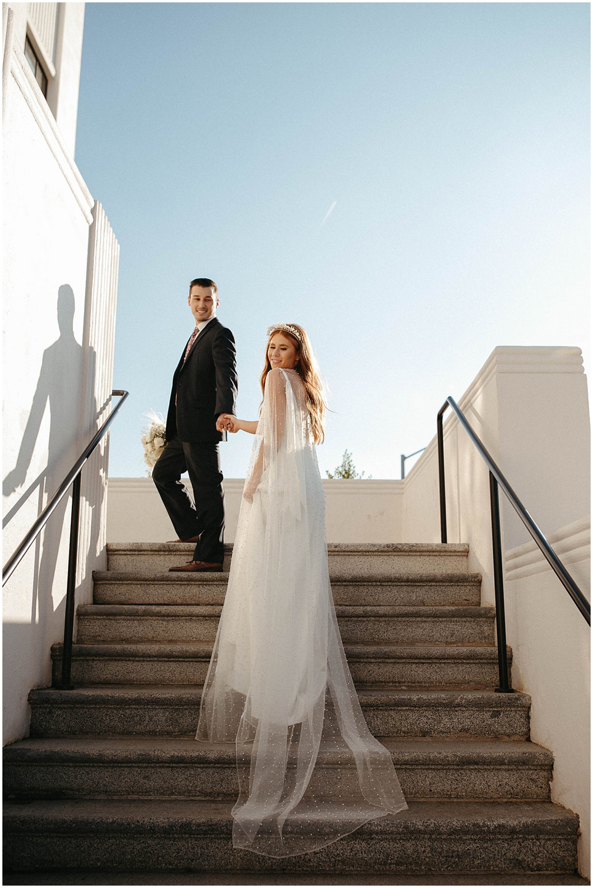 bride and groom walking up staircase