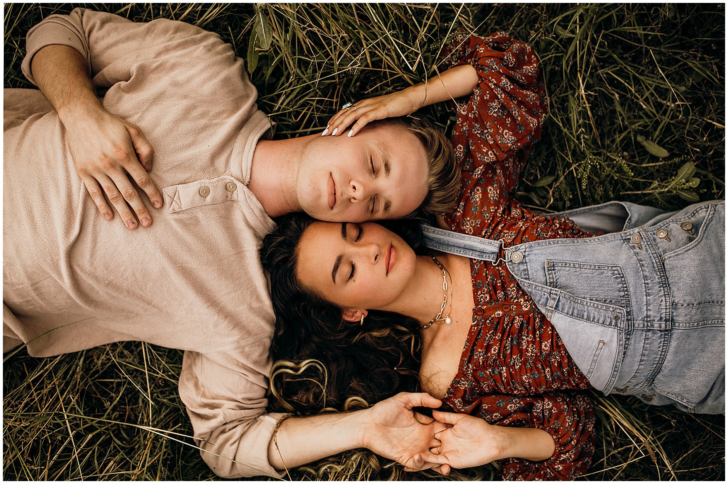 couple laying head to head in field