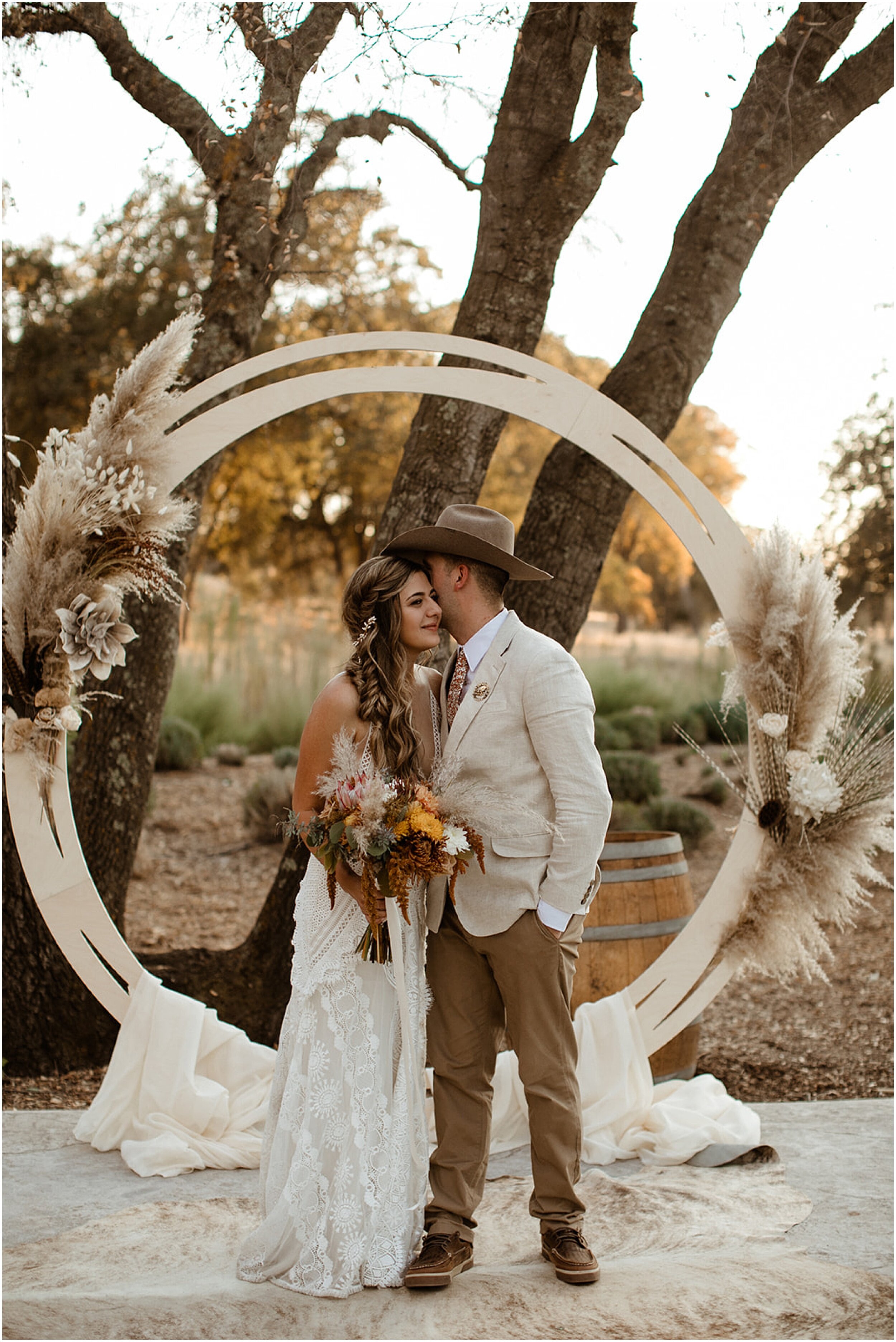 bride and groom kissing under arbor