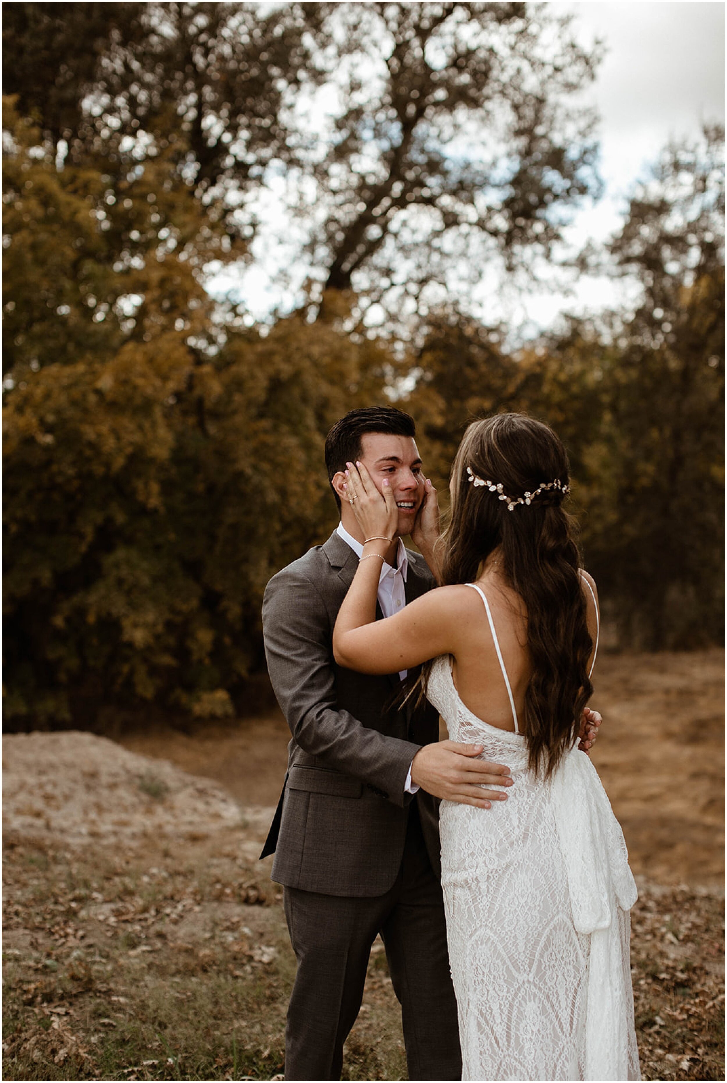 bride wiping tears off of groom's face