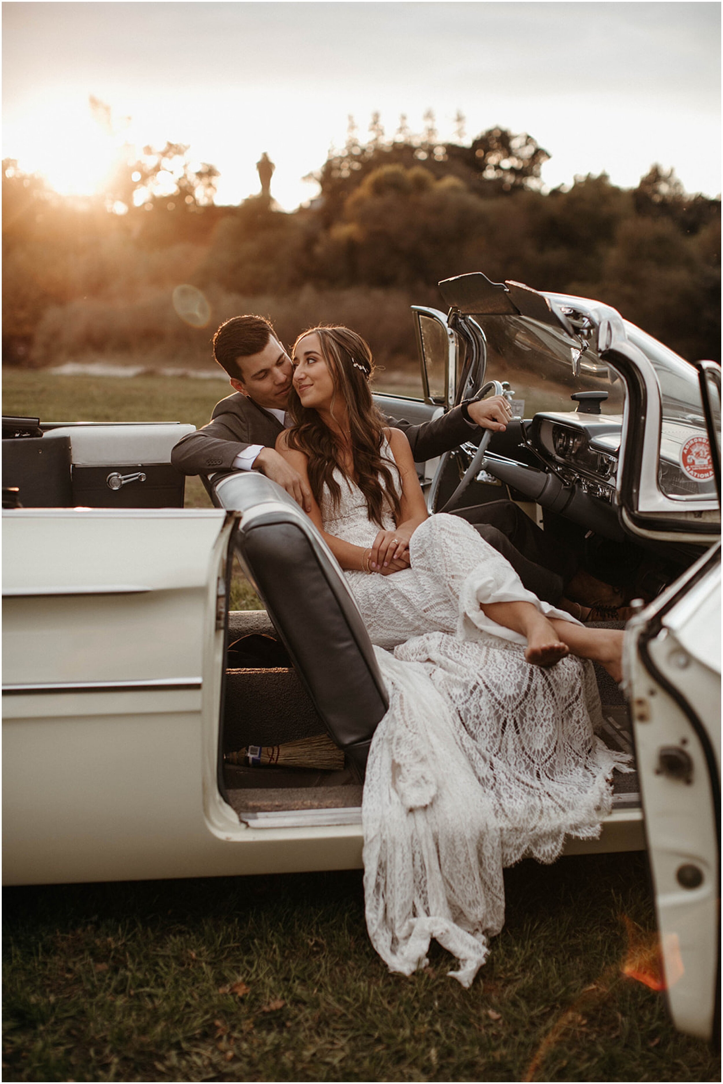 bride and groom cuddling in vintage car