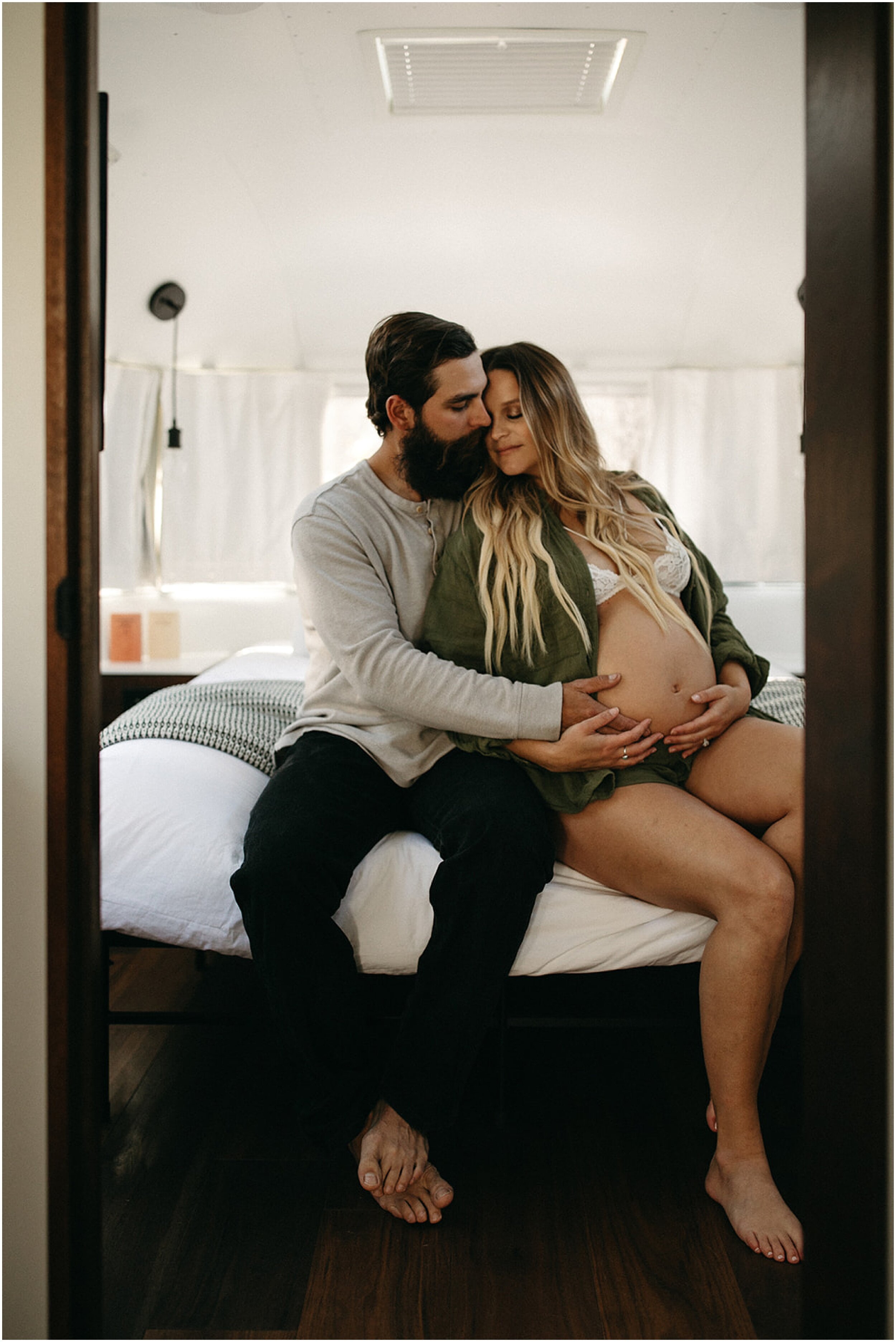 pregnant couple sitting on bed