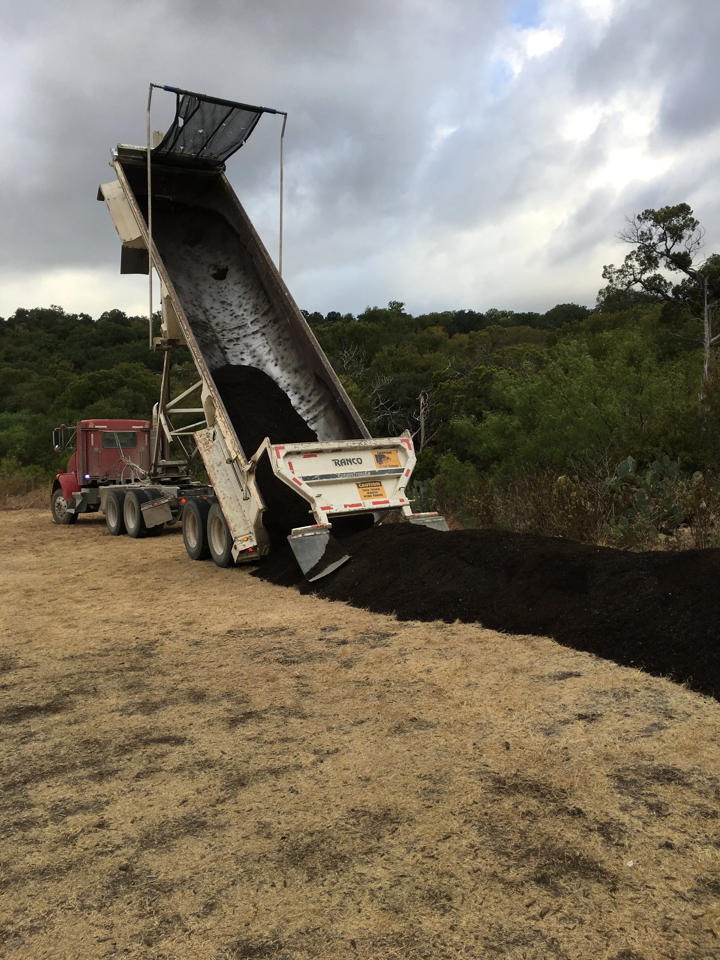 One of two dump trucks dropping off compost for the meadow