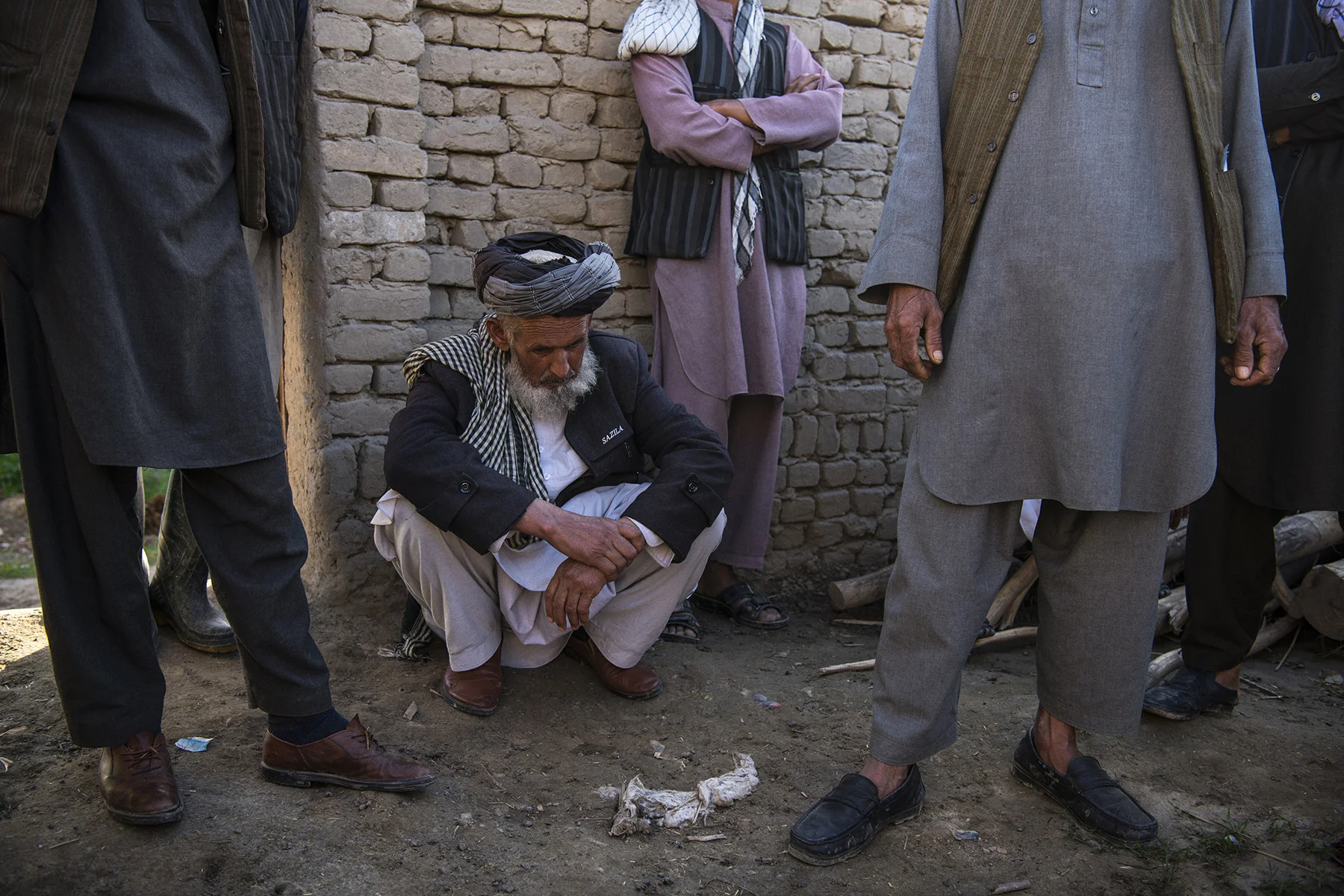 Juma Khan gathers with neighbors on March 31 at the site of what appears to be a U.S. airstrike in which 13 members of an extended family, including his daughter, son-in-law, and numerous grandchildren, were killed in the village of Aqulabul, near Telawka, north of Kunduz, Afghanistan, on March 22. ANDREW QUILTY FOR FOREIGN POLICY