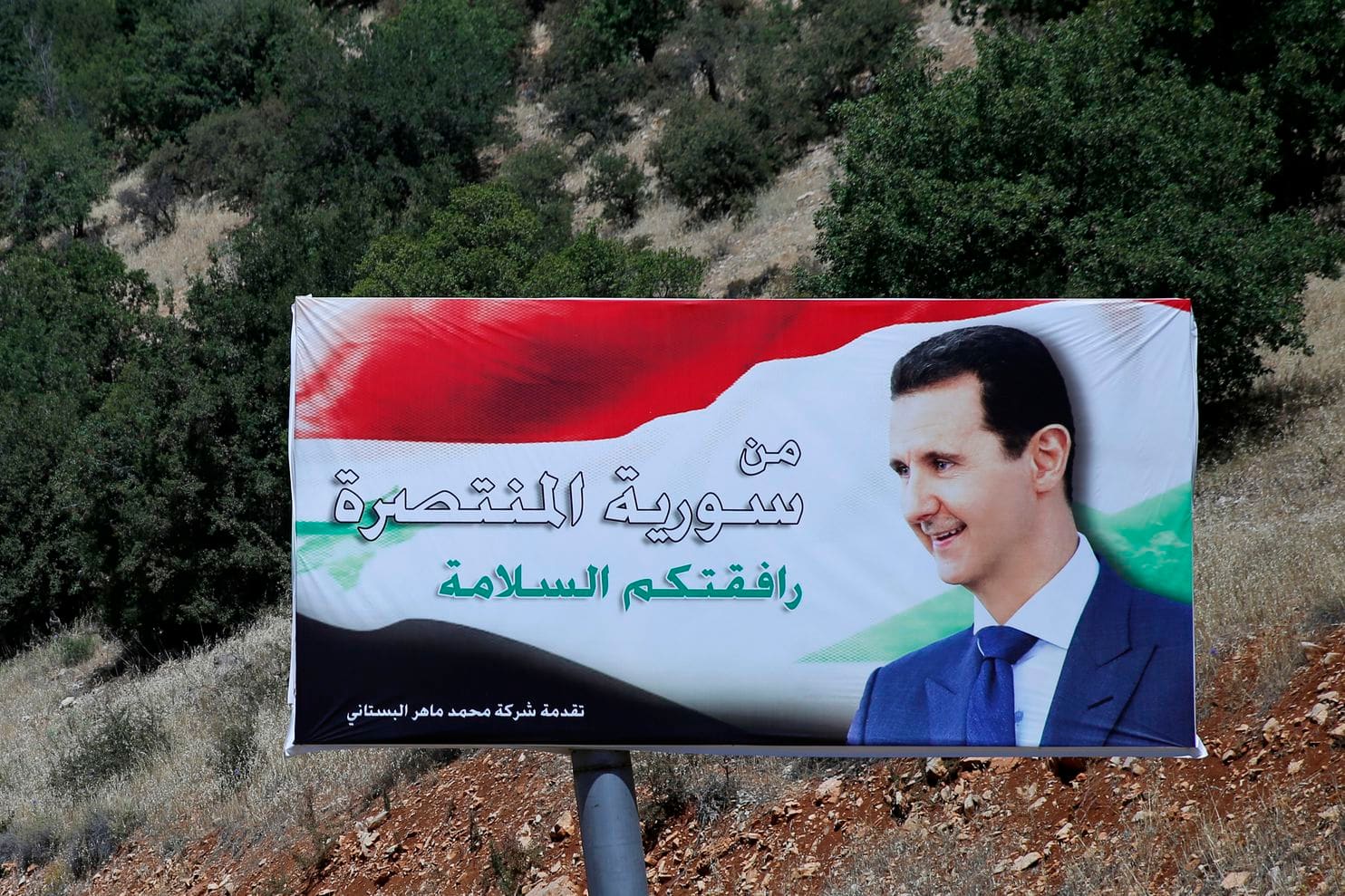 A poster of Syrian President Bashar al-Assad that reads “Welcome in victorious Syria” is displayed on the border with Lebanon in July 2018. Credit Hassan Ammar/AP