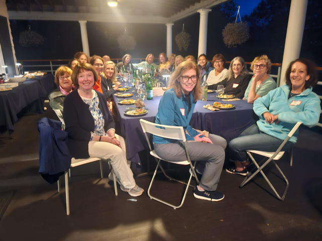Women sailors gather on the deck for a potluck dinner after the 2026 WOW Supper Series sail
