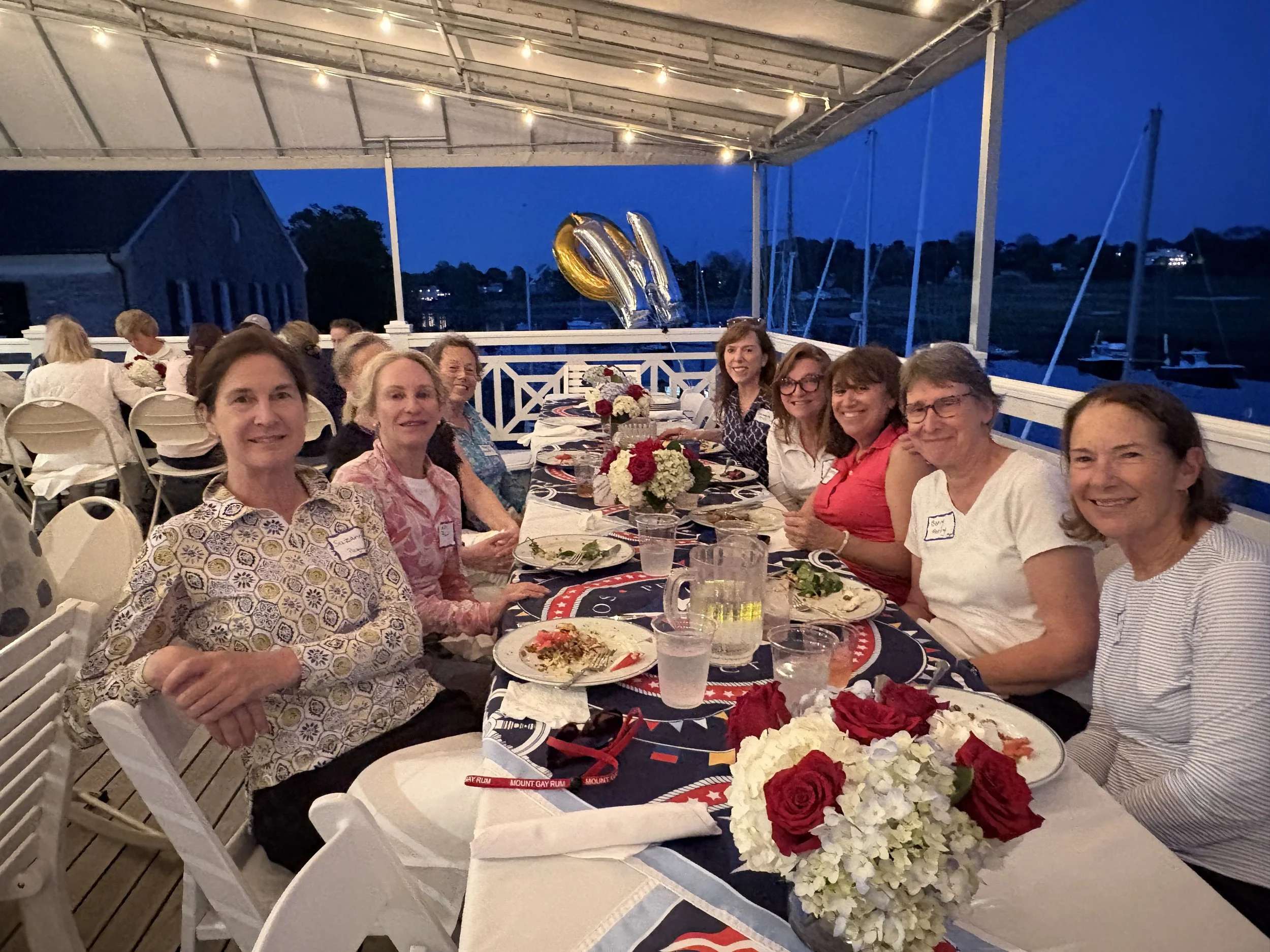 The women sailors of Pequot Yacht Club and WOW East gather on the deck for the post supper series potluck dinner, 2026