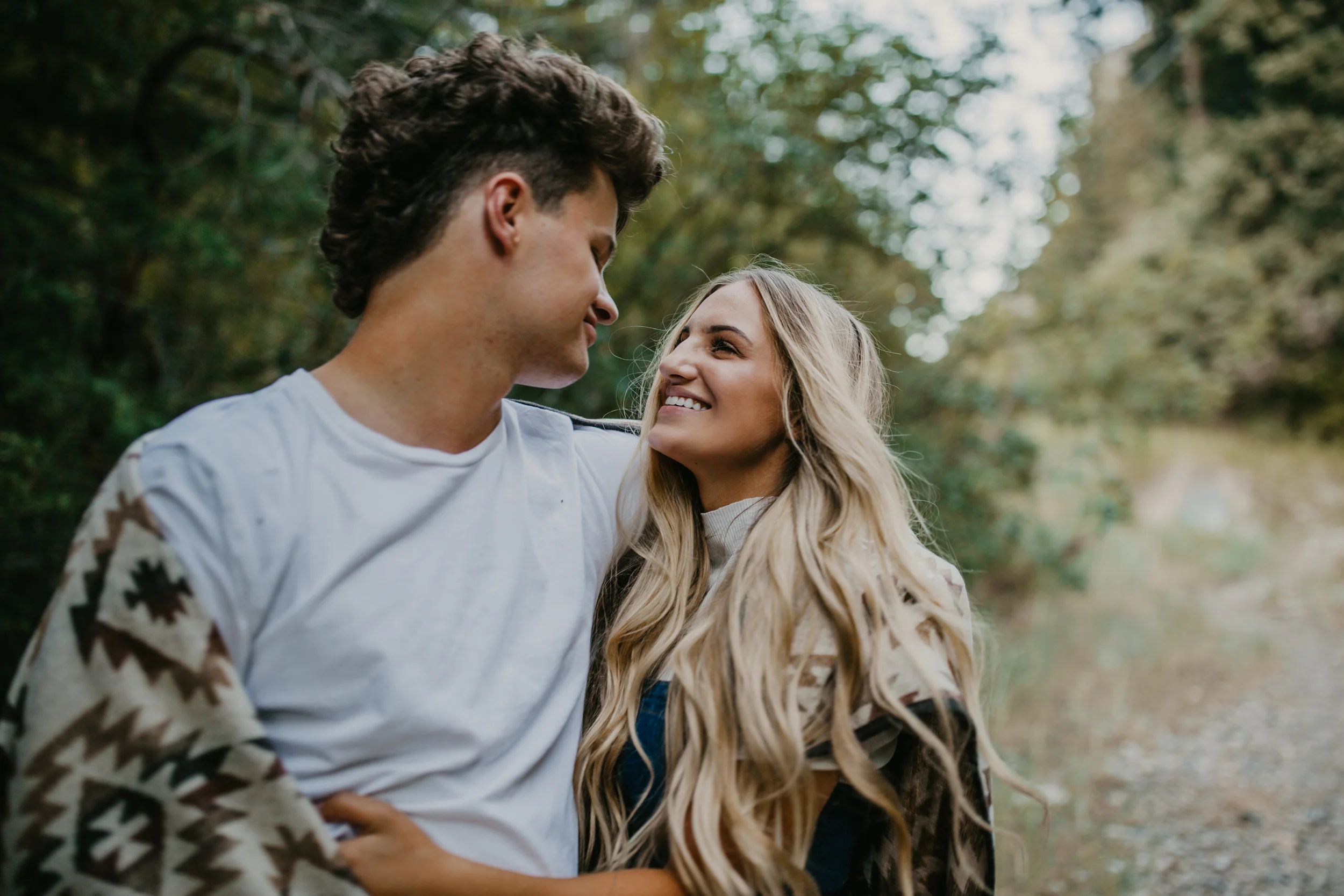 Romantic forest engagement session couple wrapped in blanket in Utah mountains long blonde hair