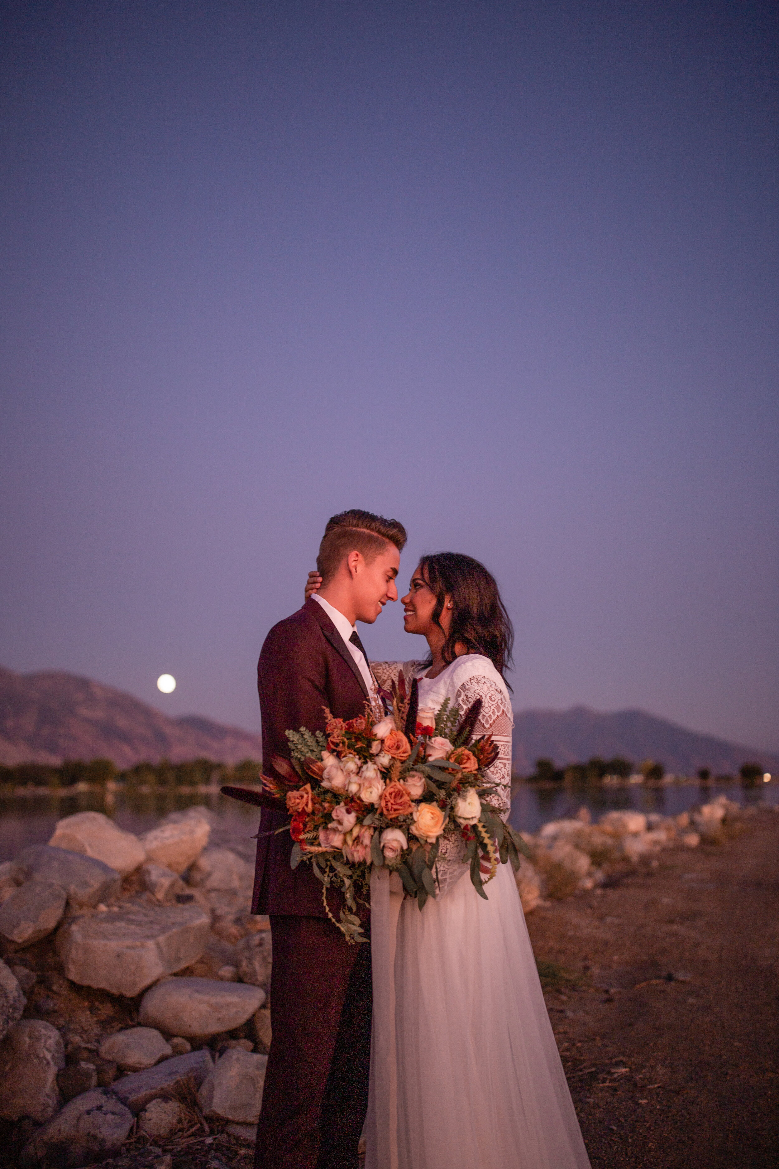 Evening nighttime full moon bridals bouquet wedding dress bride and groom lake ocean beach Utah lake marina #utahphotographer #weddingphotographer #bride #bridals #brideandgroom #weddingphotos
