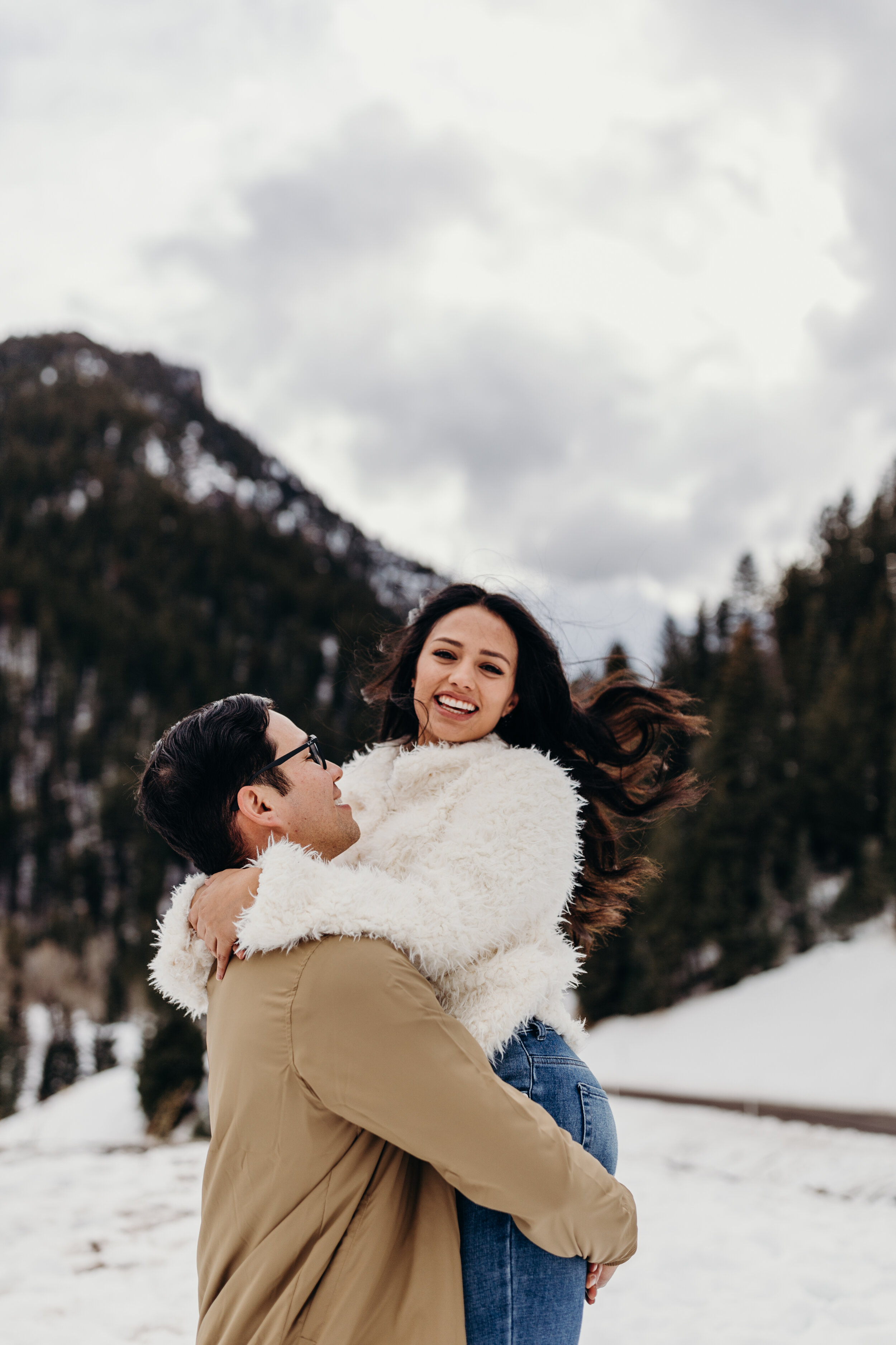 Cozy winter couple shoot snowy mountains engagement session photoshoot #coupleshoot #engagements #engagementshoot #weddingphotographer #utahphotographer guy picking up girl