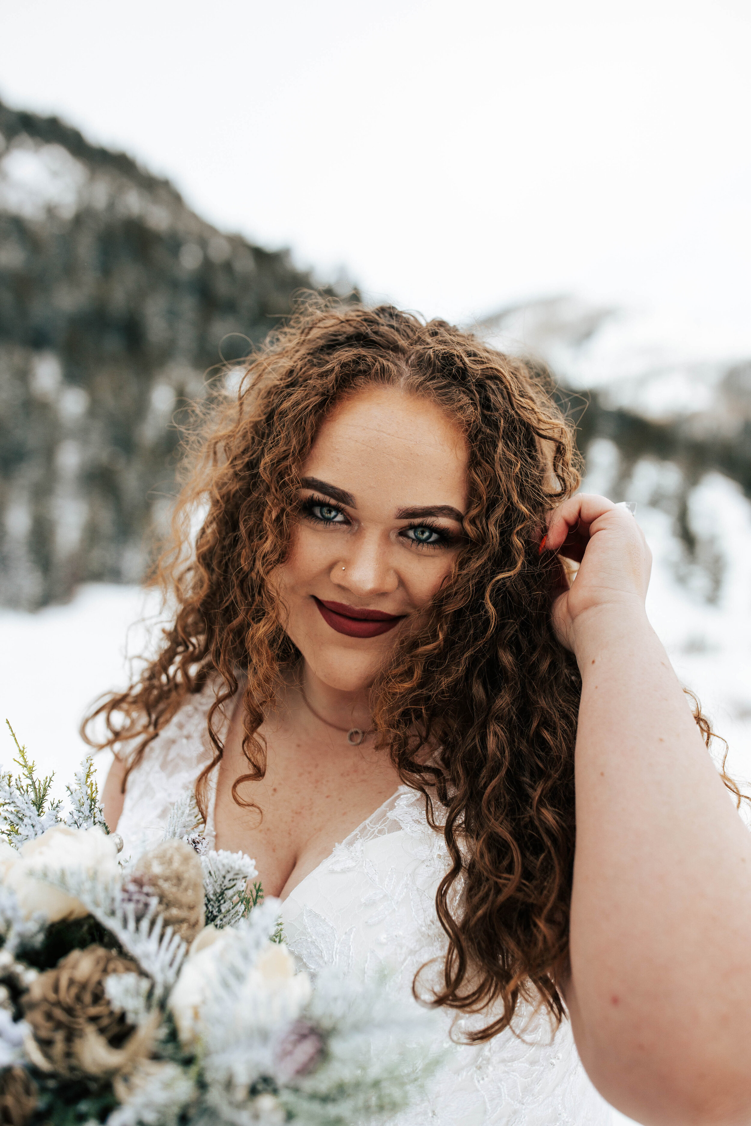 Snowy mountain winter bridals long curly hair big eyes blue florals wedding dress bride #utahphotographer #weddingphotographer #bride #bridals wedding dress