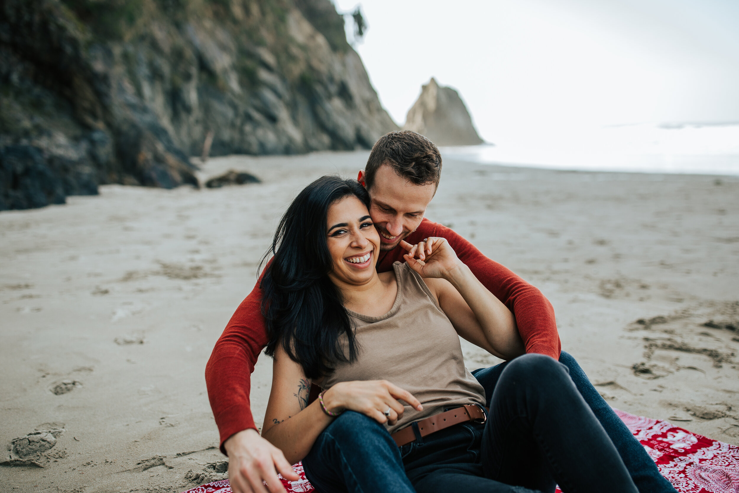 Oregon coast engagement session couple sitting down cuddling cute adventurous couples shoot at Hug Point in the PNW beach engagements #oregonphotographer #engagements 