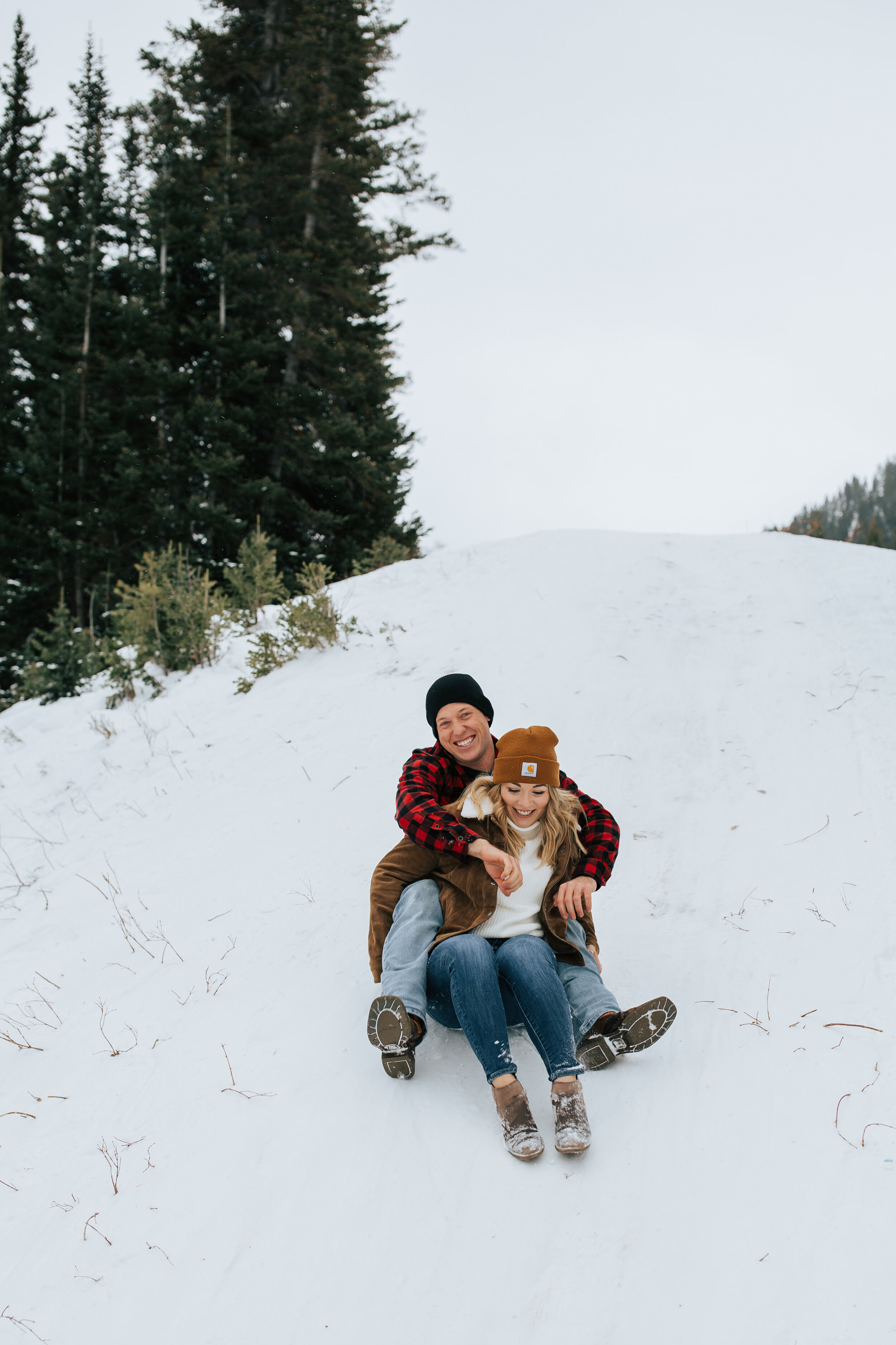 Winter engagement session in Utah mountains Big Cottonwood Canyon engagement shoot #utahphotographer #winterengagements sledding down mountain