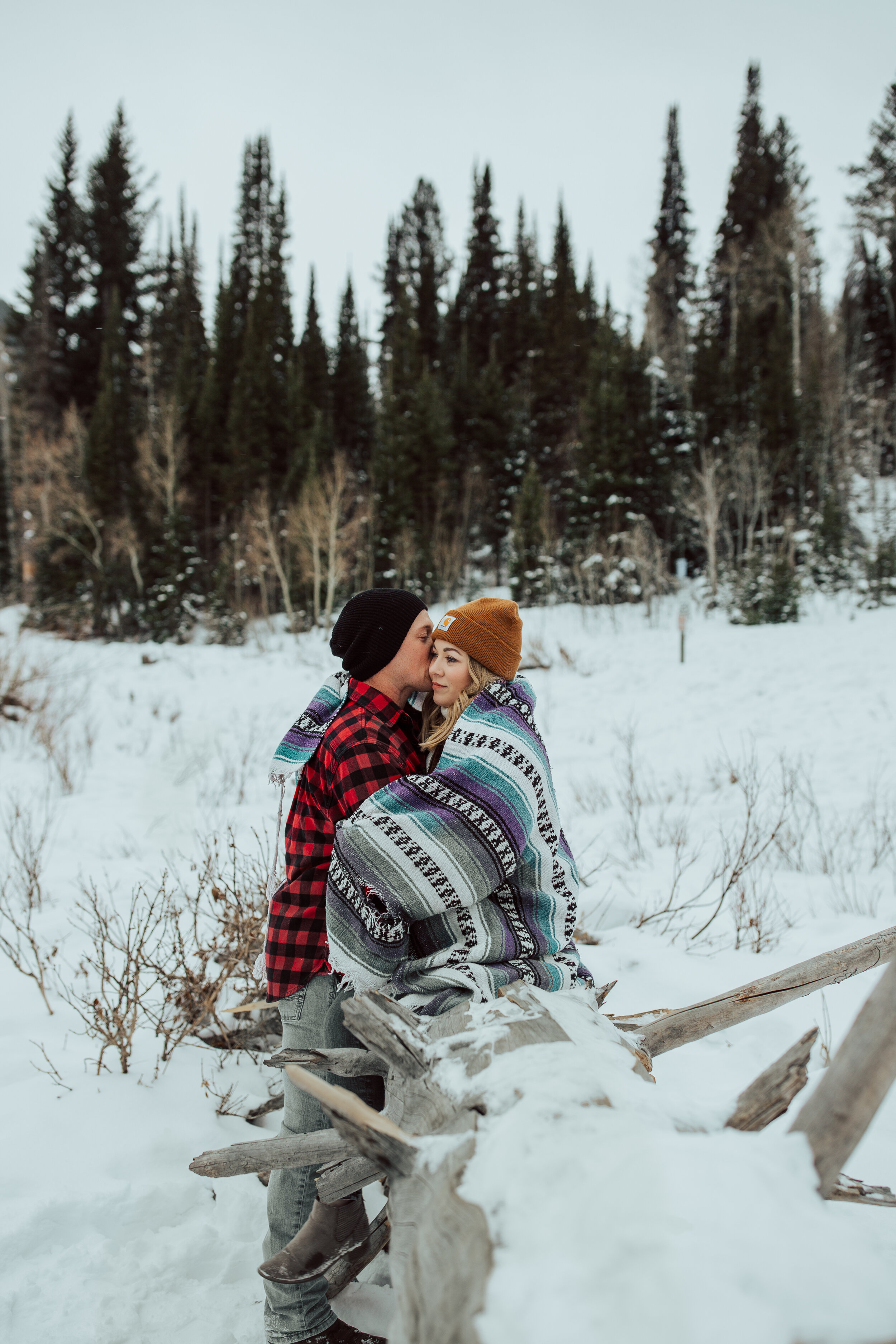 Winter engagement session in Utah mountains Big Cottonwood Canyon engagement shoot #utahphotographer #winterengagements Utah winter couple photoshoot wrapped in blanket