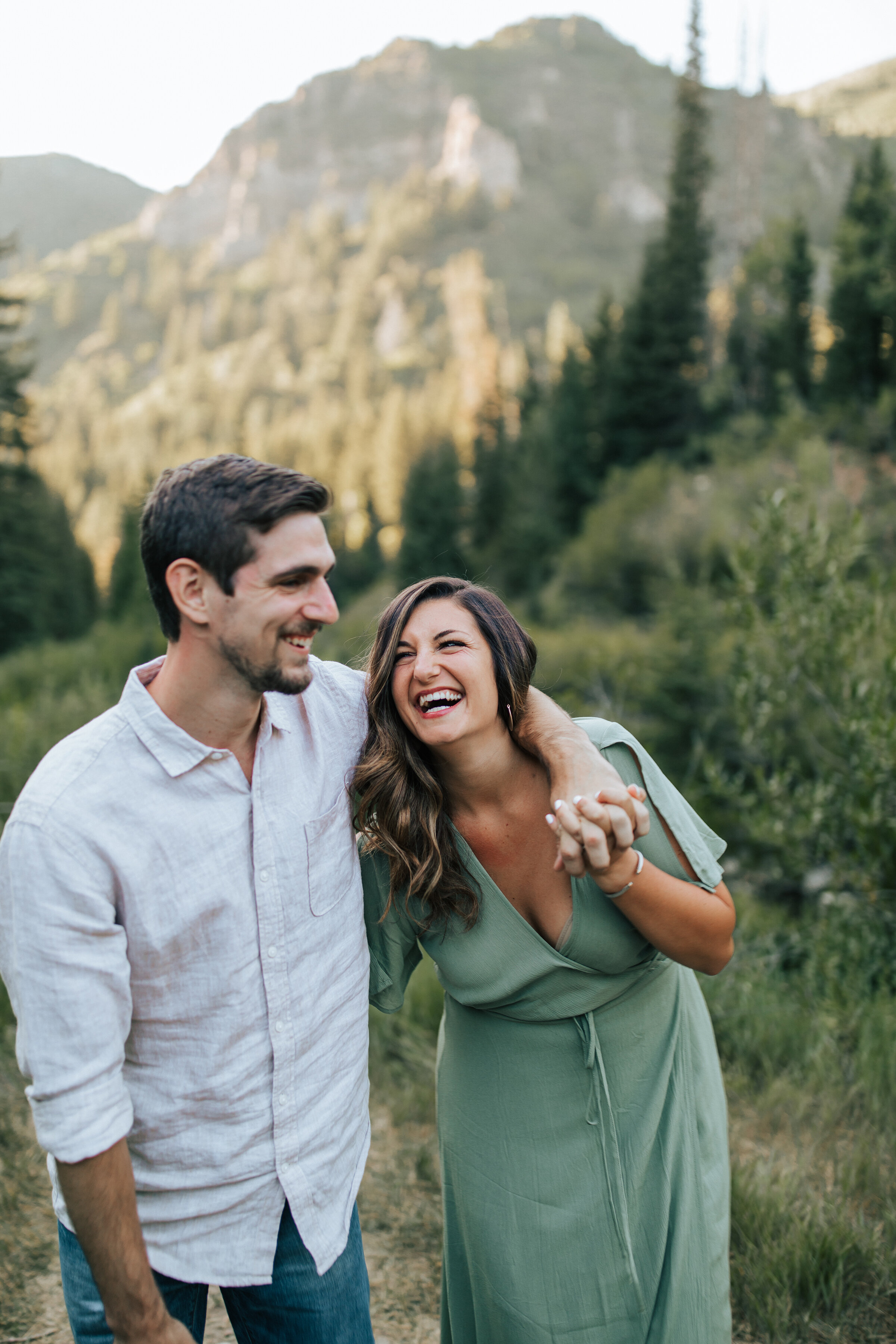 A newly wed couple laugh together in the sunny mountain in a beautiful couples honeymoon shoot by Emily Jenkins Photography. Client honeymoon attire inspiration ideas and goals honeymoon photo shoot inspiration newly wed activities outdoor photo sho