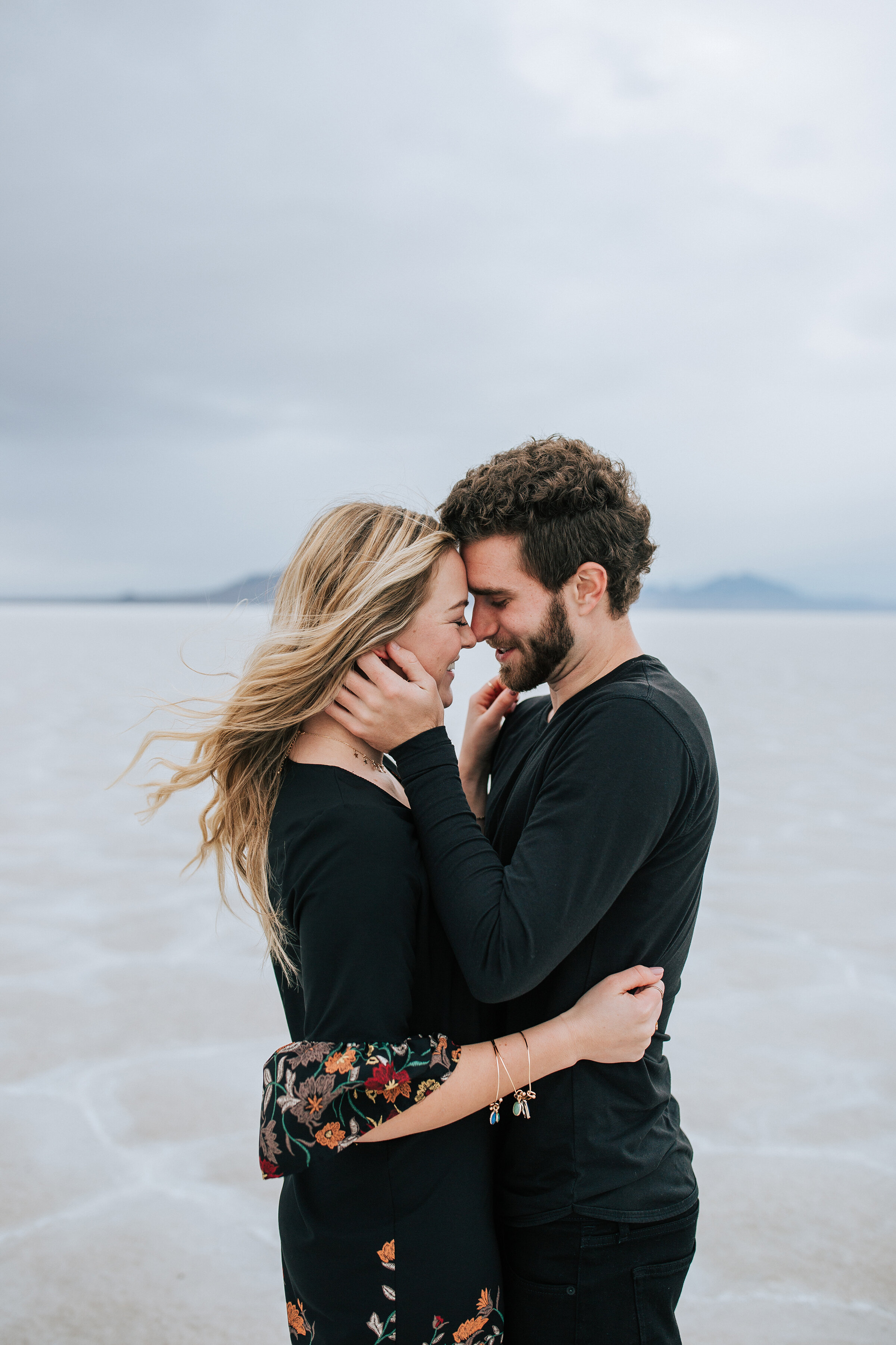  A beautiful couple hold each other close in a stunning dark and moody engagement session by Emily Jenkins Photography. Dark engagement session attire inspiration ideas and goals client attire inspiration ideas and goals couple goals couple pose insp