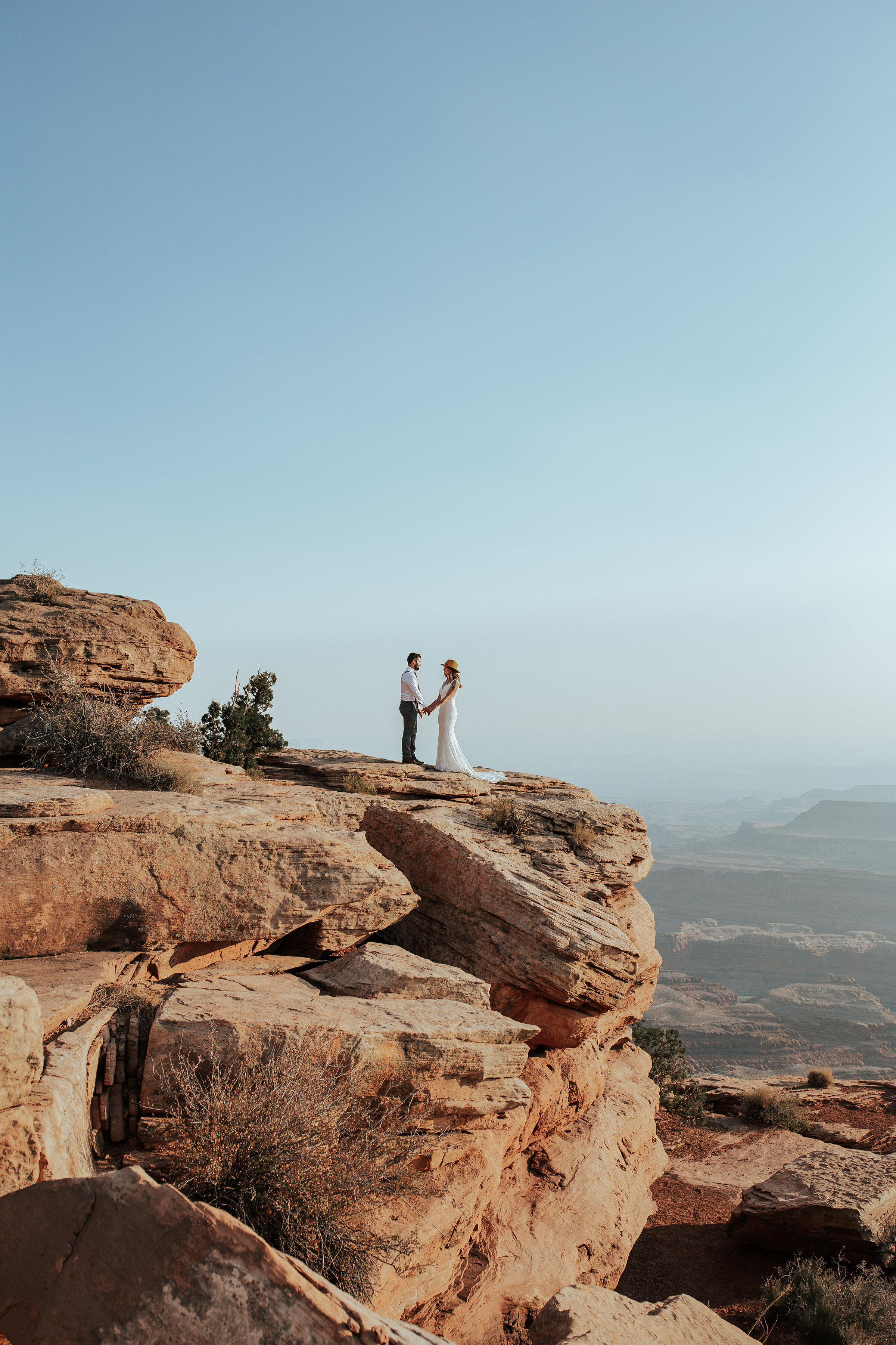  A newly married couple stand on the edge of a cliff in a gorgeous elopement styled photo shoot by professional Utah photographer Emily Jenkins Photography. Why you should elope in Utah outdoor elopement photo shoot inspiration ideas and goals couple