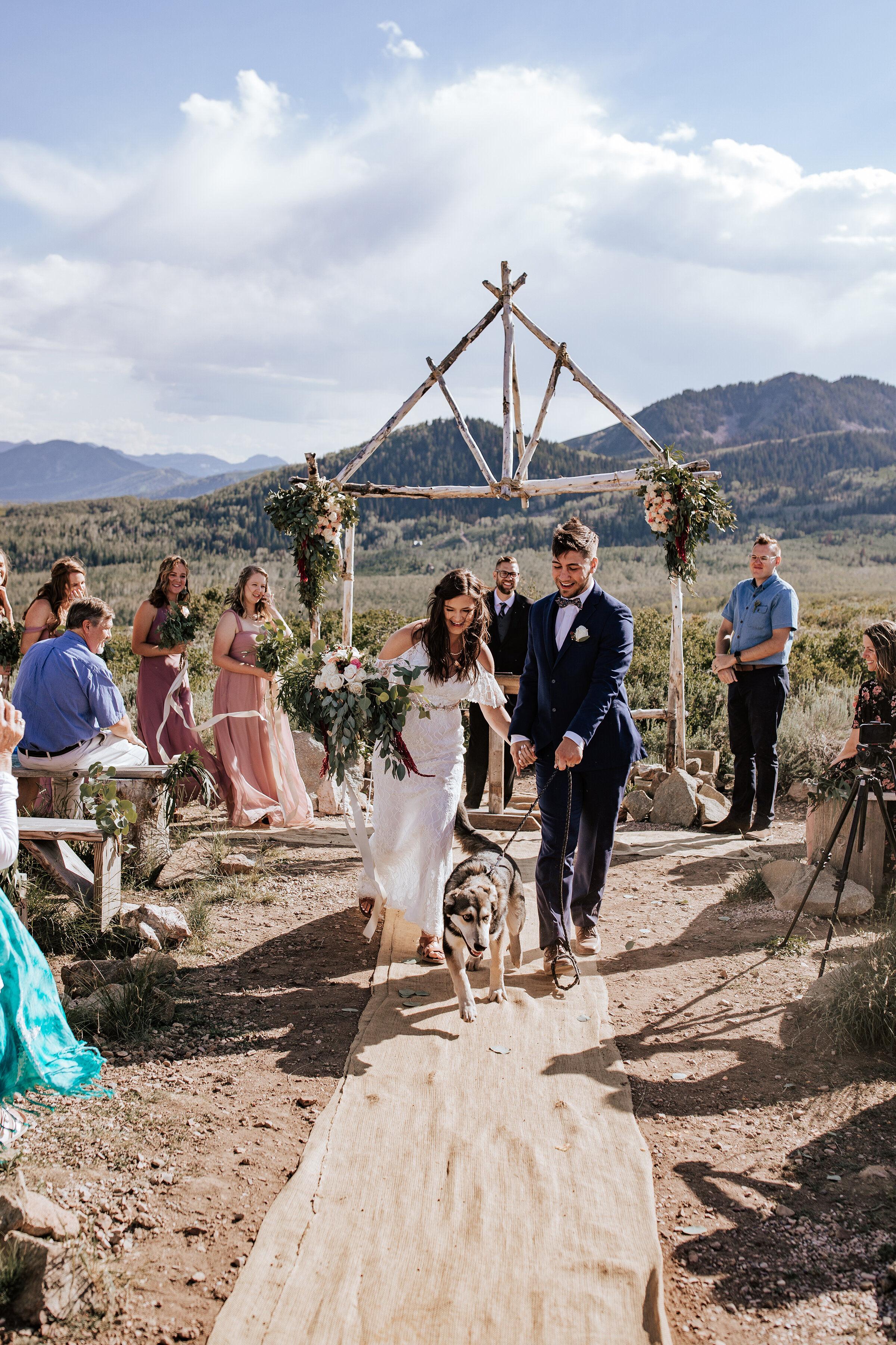  A newly married husband and wife walk down the dusty isle in a rustic desert themed elopement in the Utah desert. Professional elopement photographer Emily Jenkins Photography rustic desert themed wedding inspiration ideas and goals unique wedding a