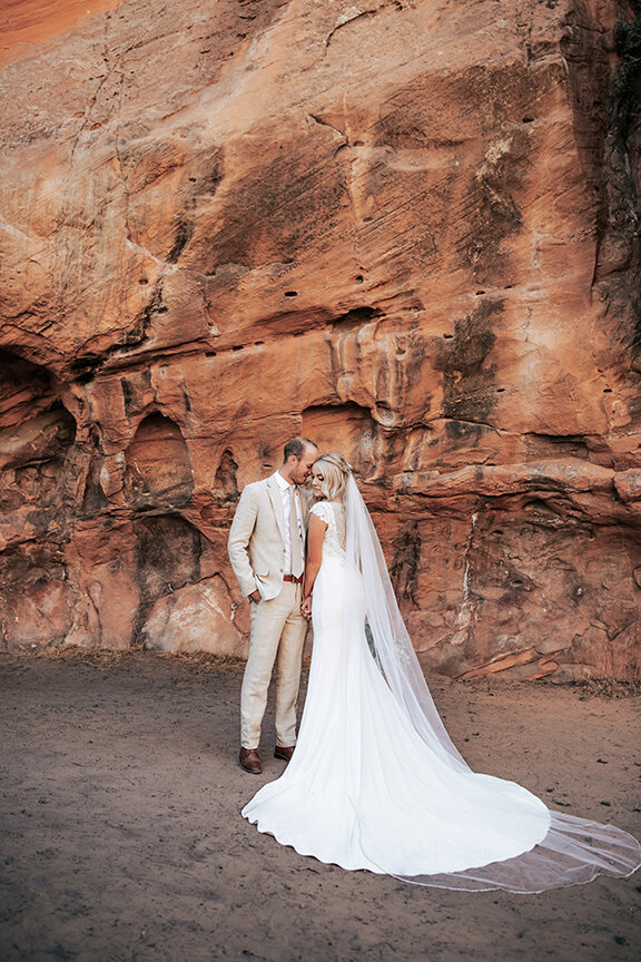  A stunning bride and groom stand in the beautiful red rocks of Utah in an elopement styled photo shoot by Emily Jenkins Photography. Wedding goals wedding photo shoot location inspiration ideas and goals wedding attire inspiration couple goals why y