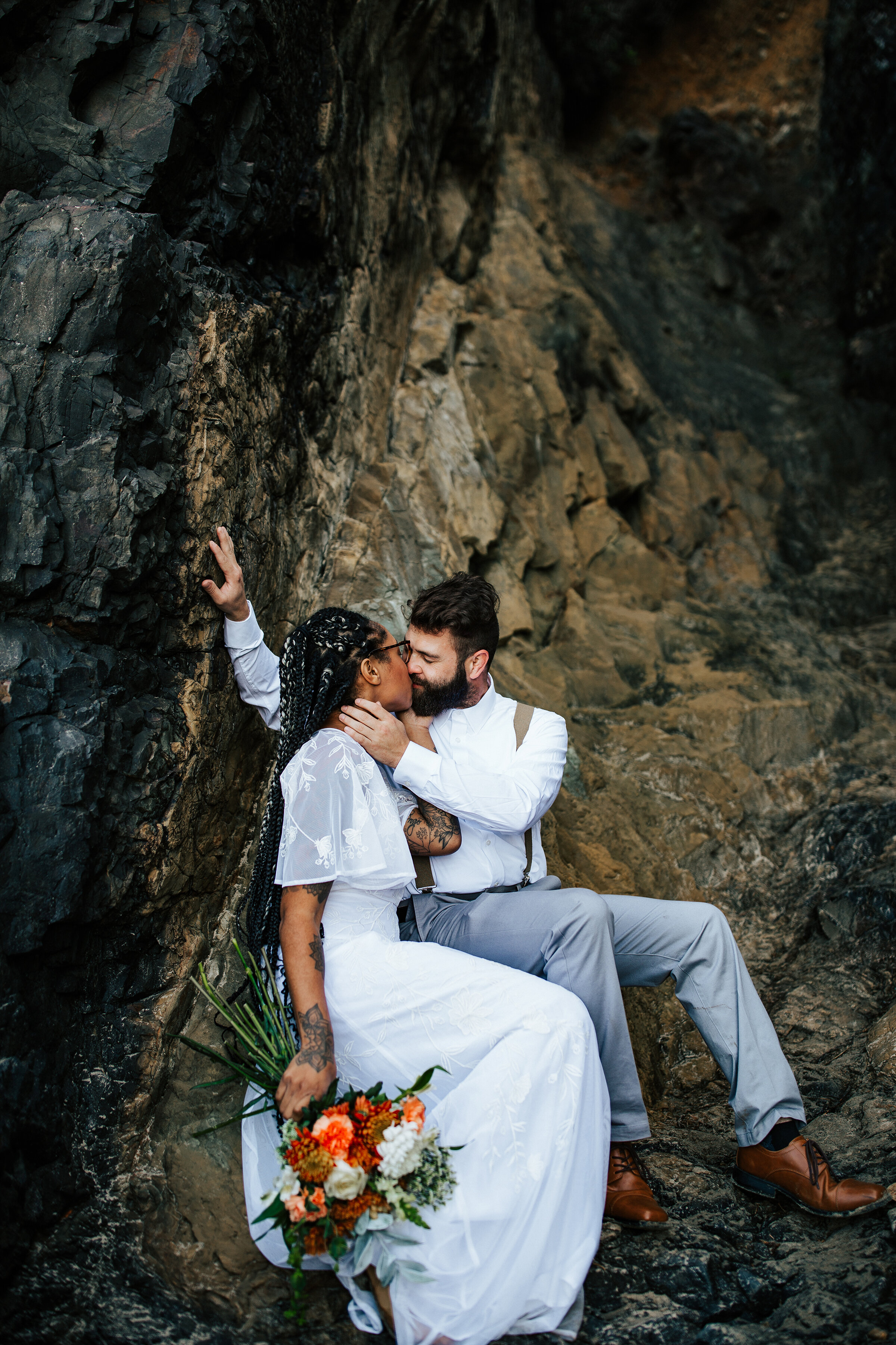  A gorgeous couple kiss in the rocks of the Oregon Coast in a romantic elopement styled photo shoot by Emily Jenkins Photography. Elopement goals wedding dress inspiration elopement wedding dress inspiration ideas and goals groom attire inspiration o