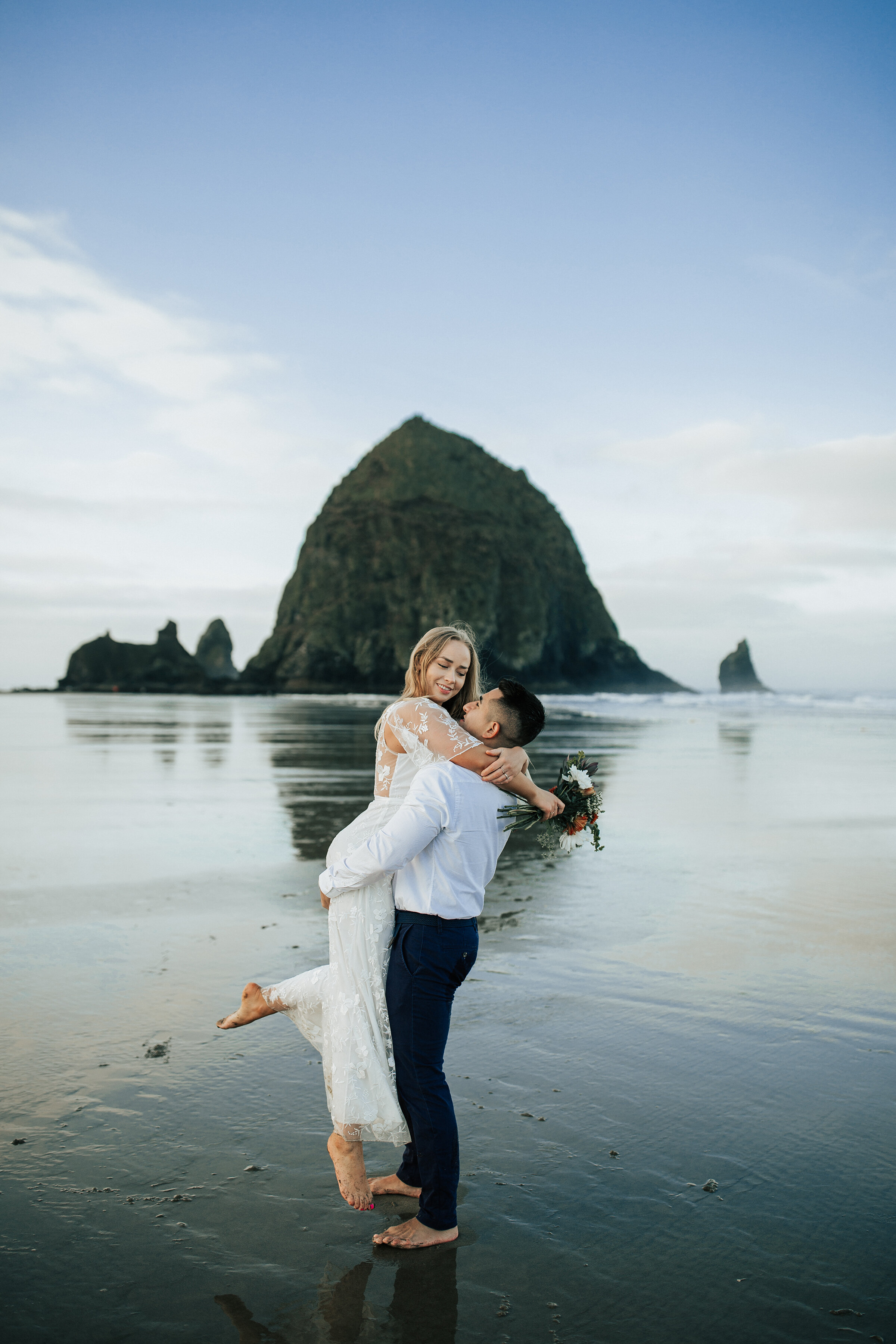  A handsome groom lifts his bride on the scenic Oregon Coast in an elopement styled photo shoot. Emily Jenkins Photography couple pose inspiration ideas and goals three places to elope on the Oregon Coast client attire inspiration for elopements coup