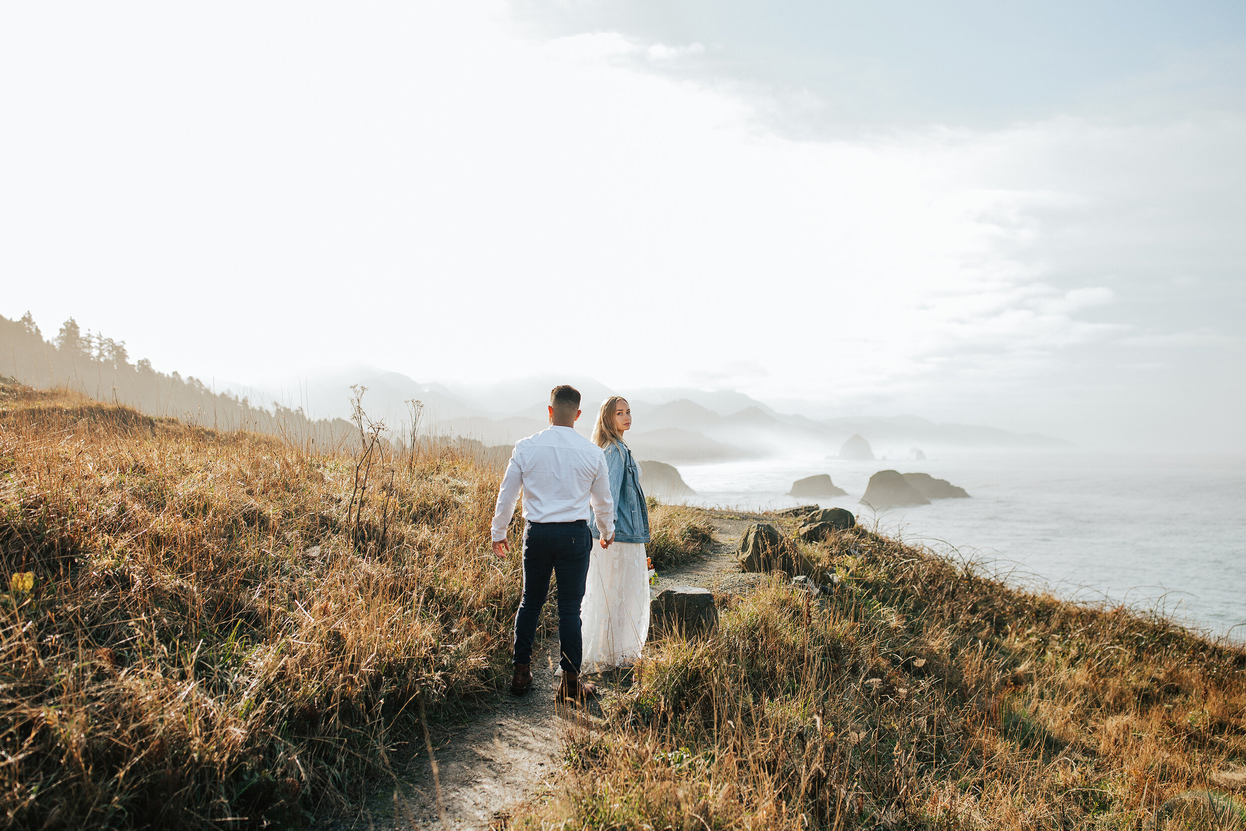  A beautiful couple walk along the cliffs of the Oregon Coast in a stunning bright and airy elopement photo shoot by Emily Jenkins Photography. Three places to elope on the Oregon Coast couple goals couple pose inspiration ideas and goals client atti