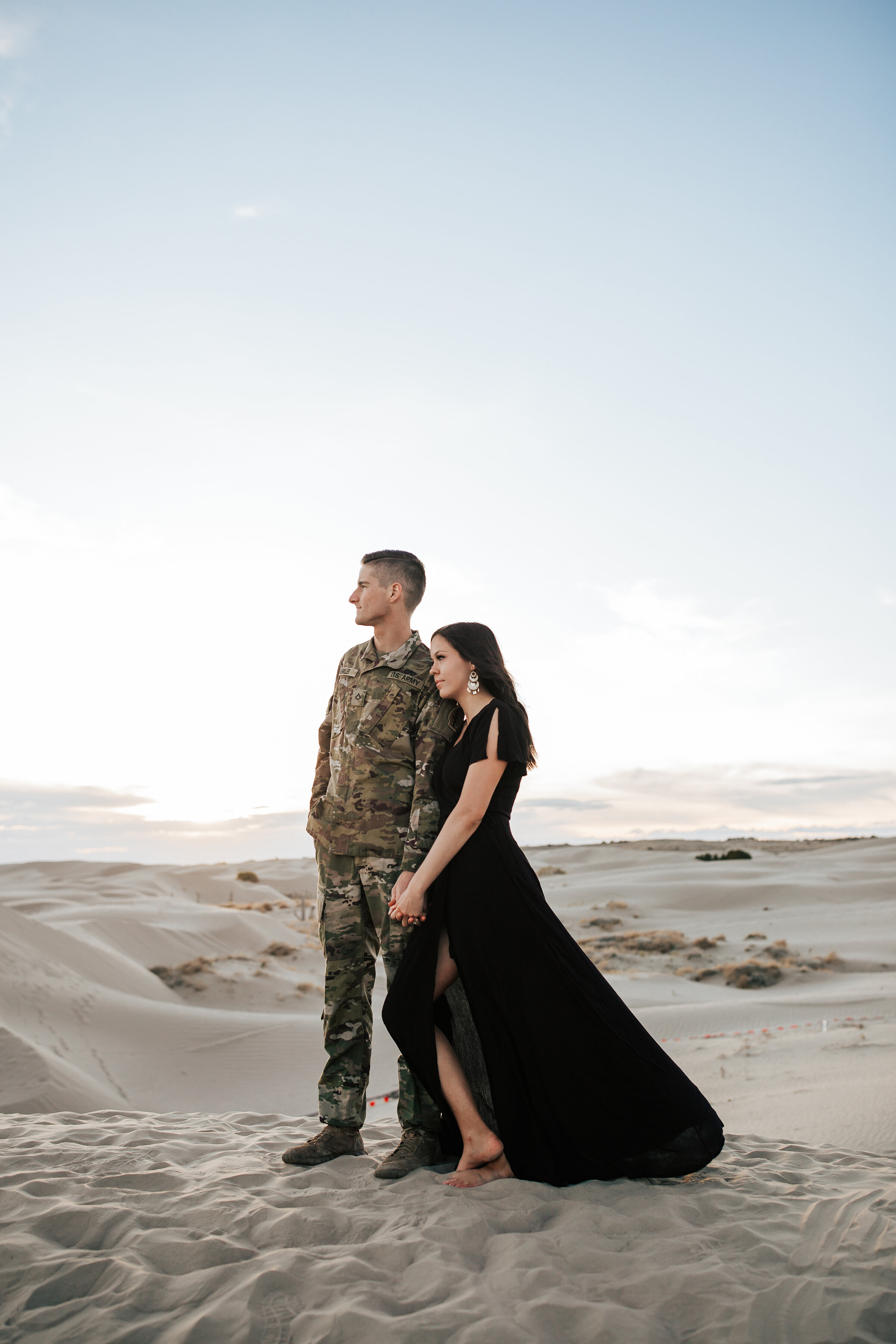  A beautiful couple look off into the distance in a stunning engagement photo shoot in Utah. Emily Jenkins Photography semi formal client attire inspiration ideas and goals for women service man Utah photo shoot location inspiration ideas and goals c