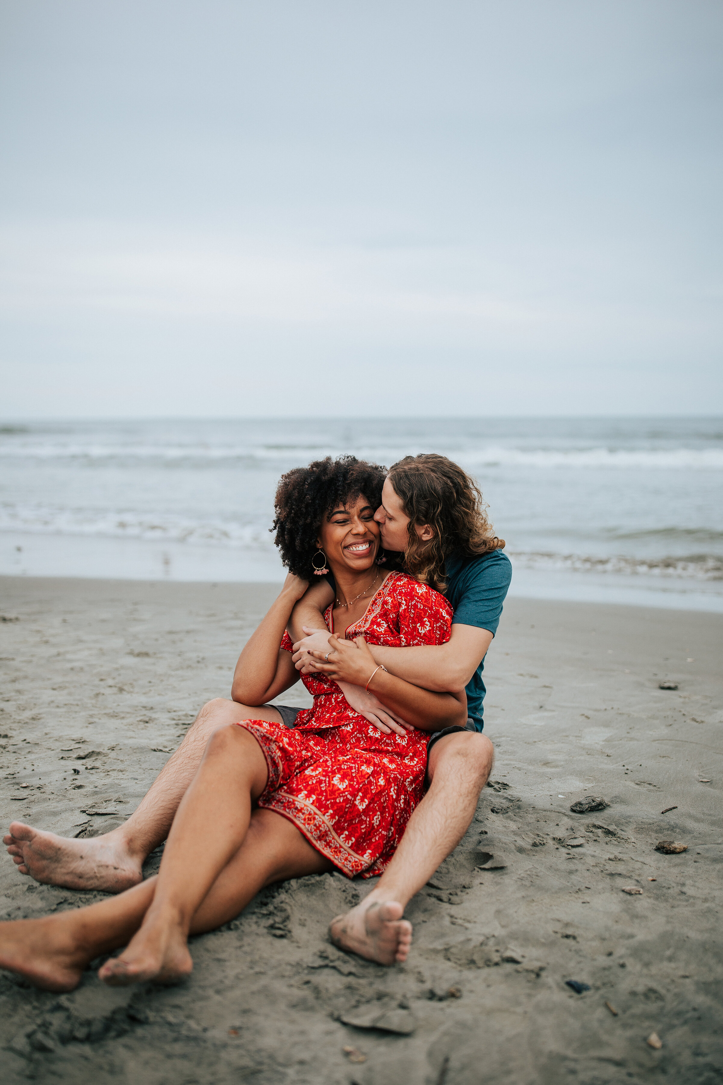  Loving couple sit on the beach in a unique engagement session by professional photographer Emily Jenkins Photography. Couple goals couple pose inspiration ideas and goals sitting couple pose engagement attire inspiration for women engagement outfit 