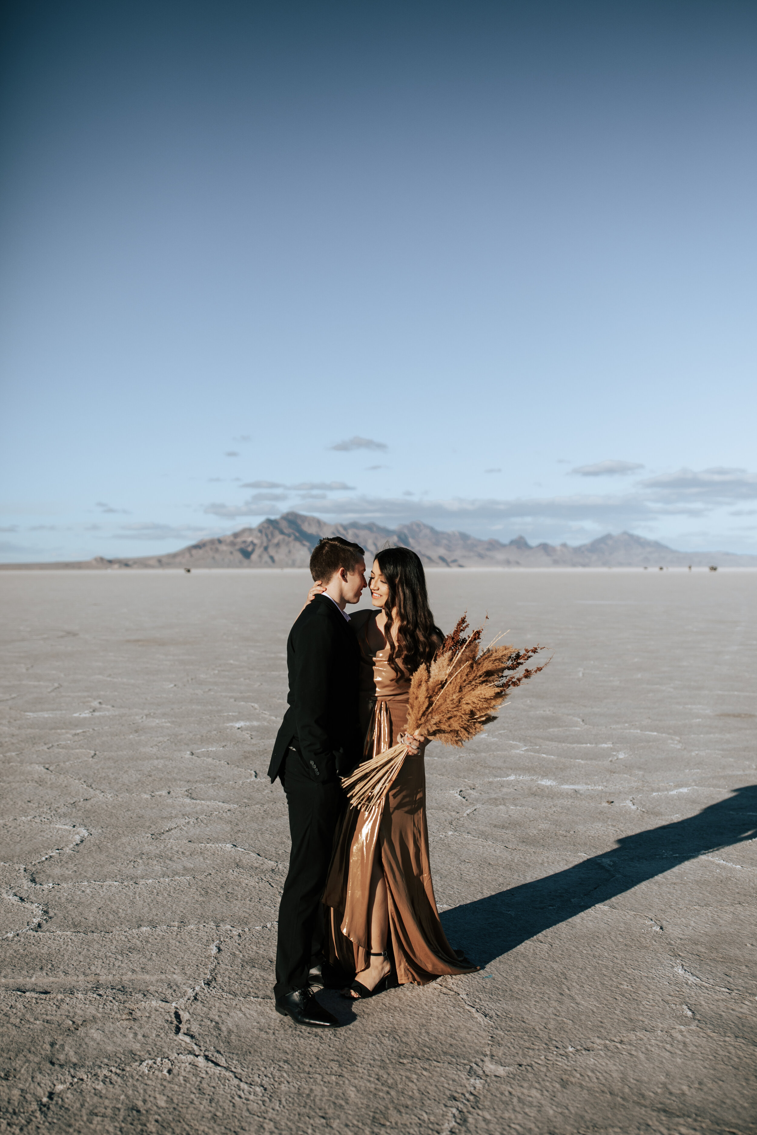  Bohemian style couple photoshoot with the couple wearing neutrals while going in for a kiss by Emily Jenkins Photography in Zion, Utah. Utah salt flats Neutral couple photography bohemian dress and bouquet salt flat pic ideas vow renewal photographe