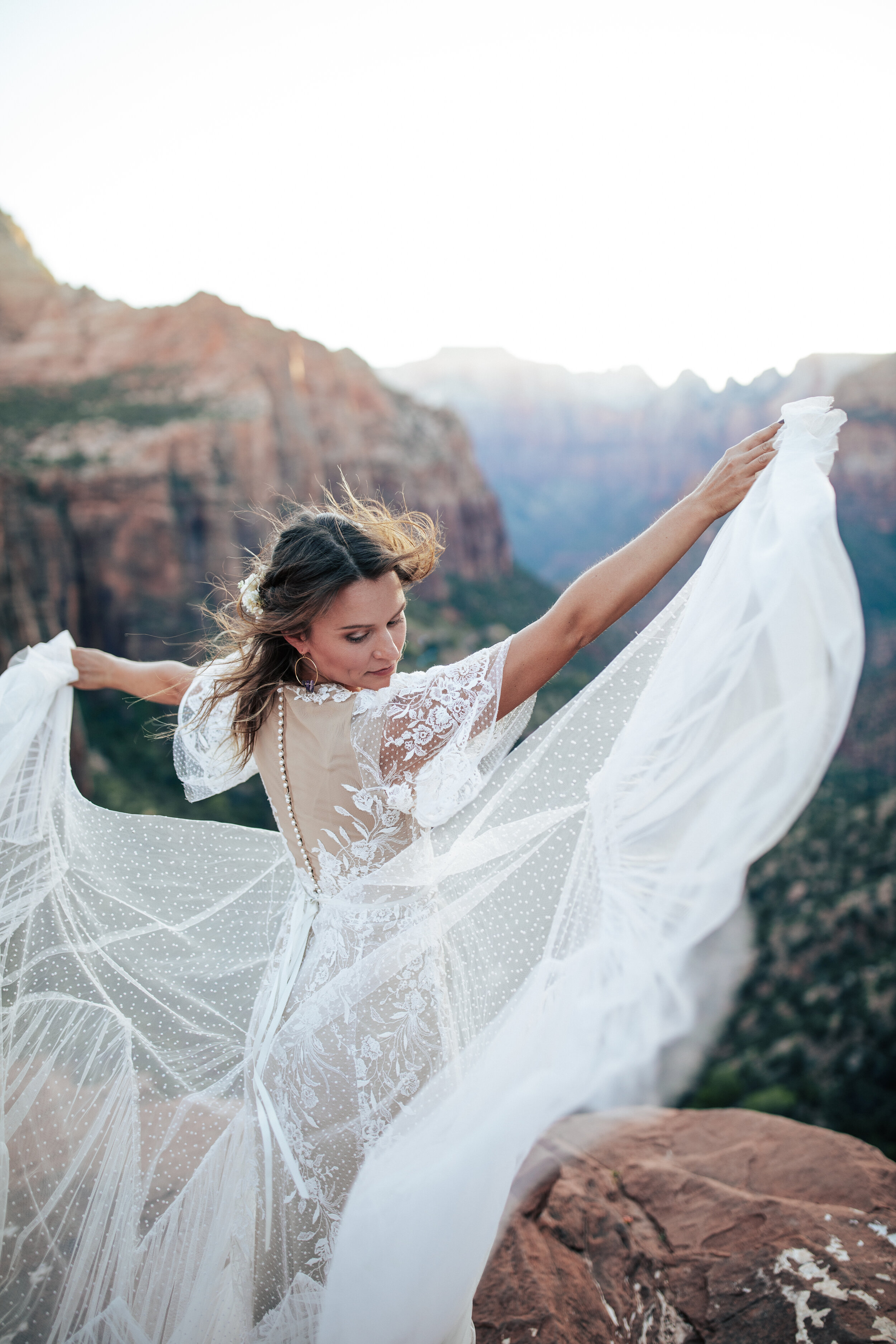 A stunning bride dances on the cliffs in Zion National Park in a unique elopement styled photo shoot by Emily Jenkins Photography. Bridal aesthetic goals unique lace wedding dress inspiration ideas and goals bridal pose inspiration ideas and goals o
